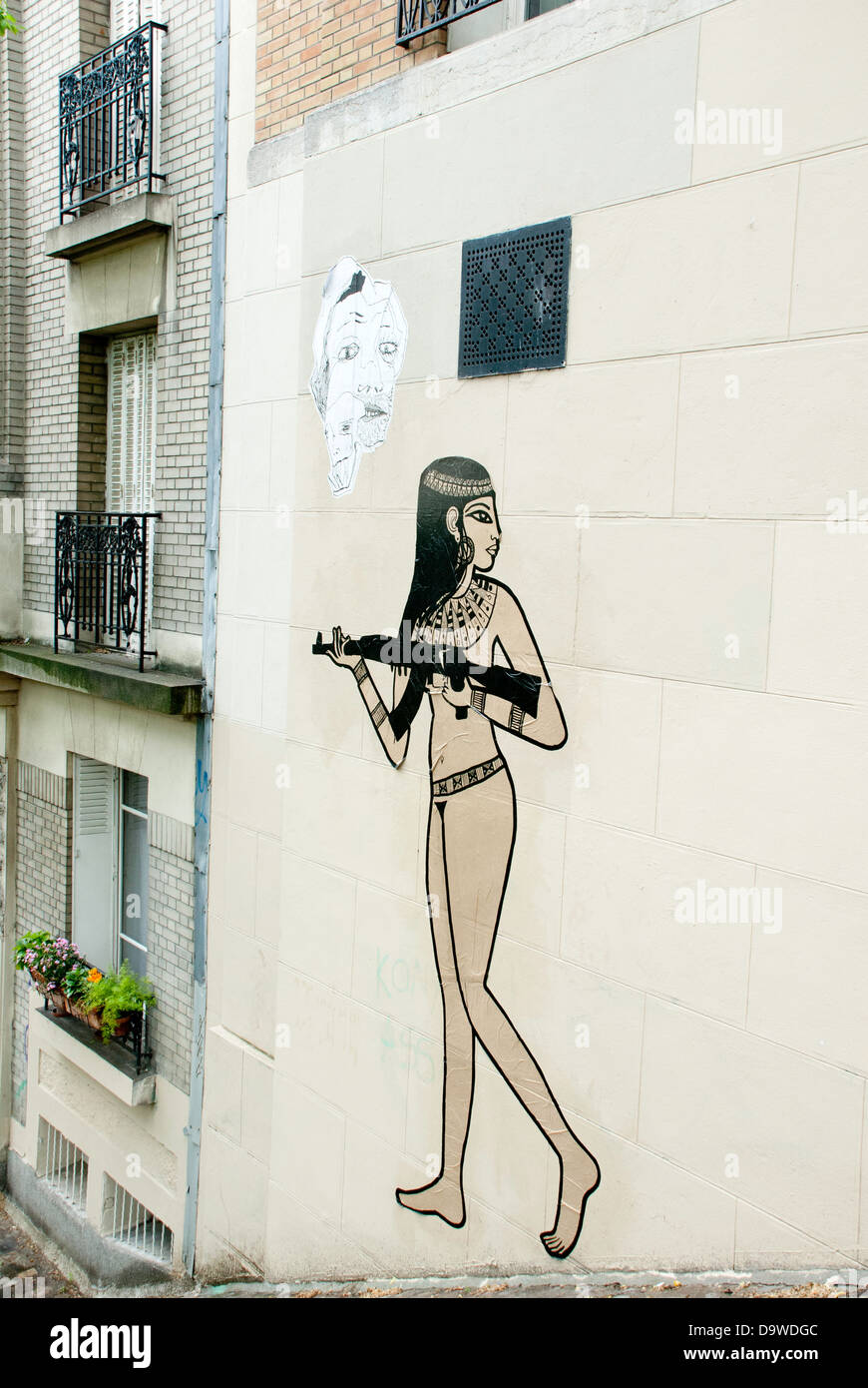 Graffiti/collage art on a wall in Rue Foyatier, Paris, depicting Egyptian woman holding a machine gun Stock Photo