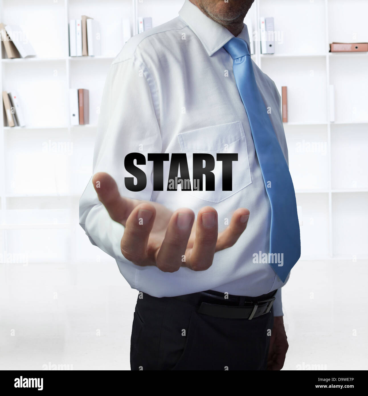 Elegant businessman holding the word start Stock Photo