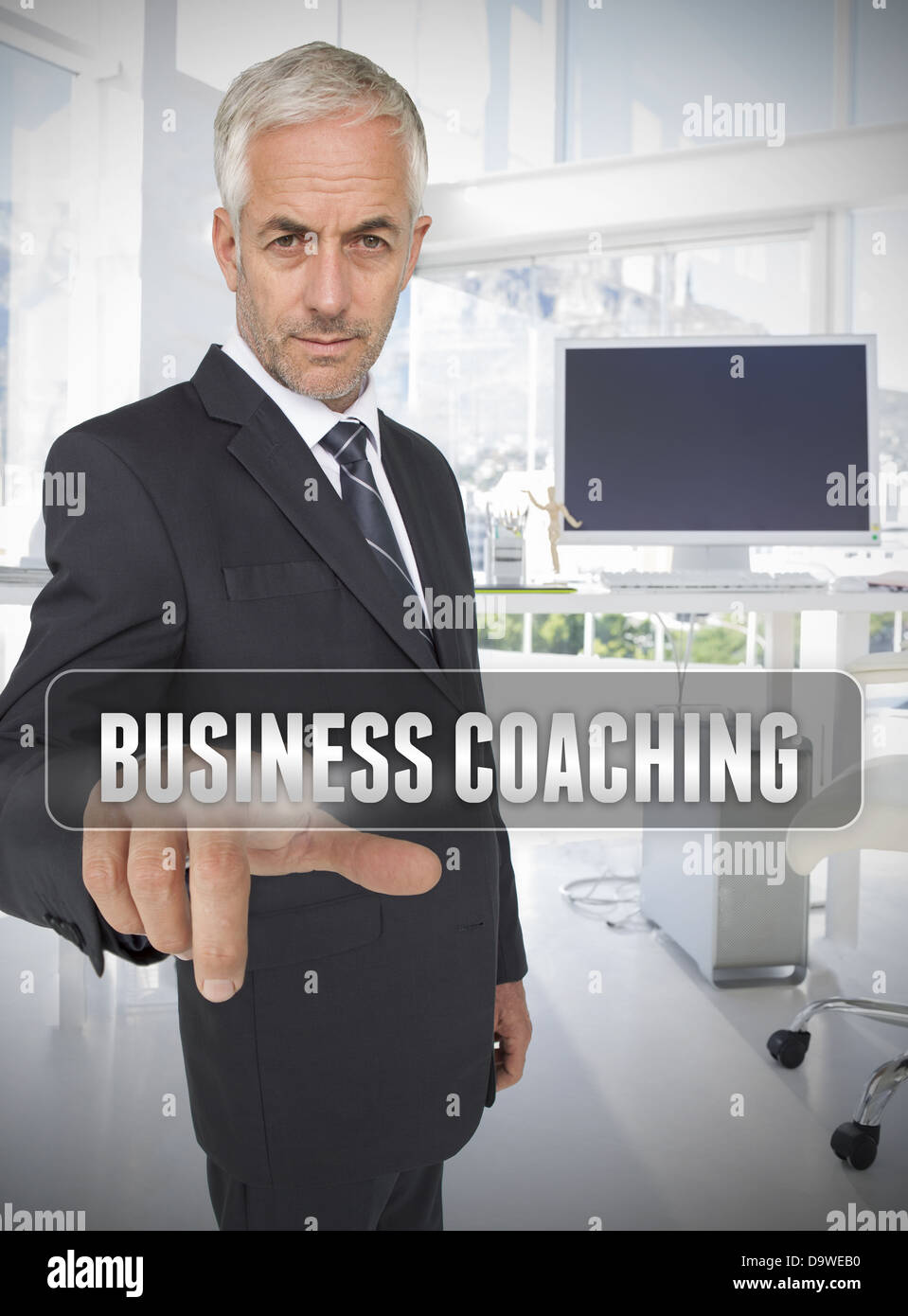 Businessman touching the term business coaching Stock Photo