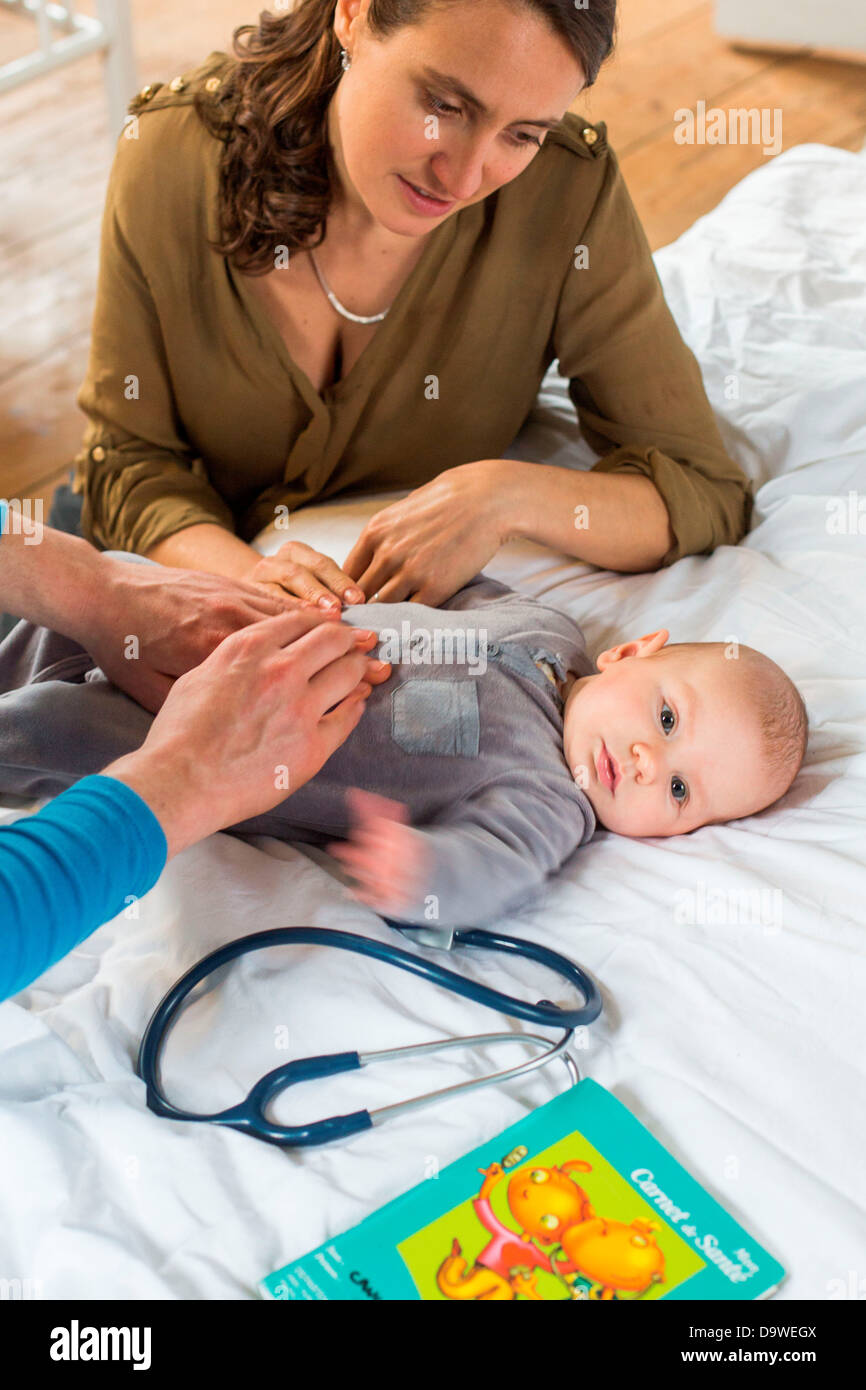 Doctor palpating the abdomen of a 5-month-old baby boy Stock Photo