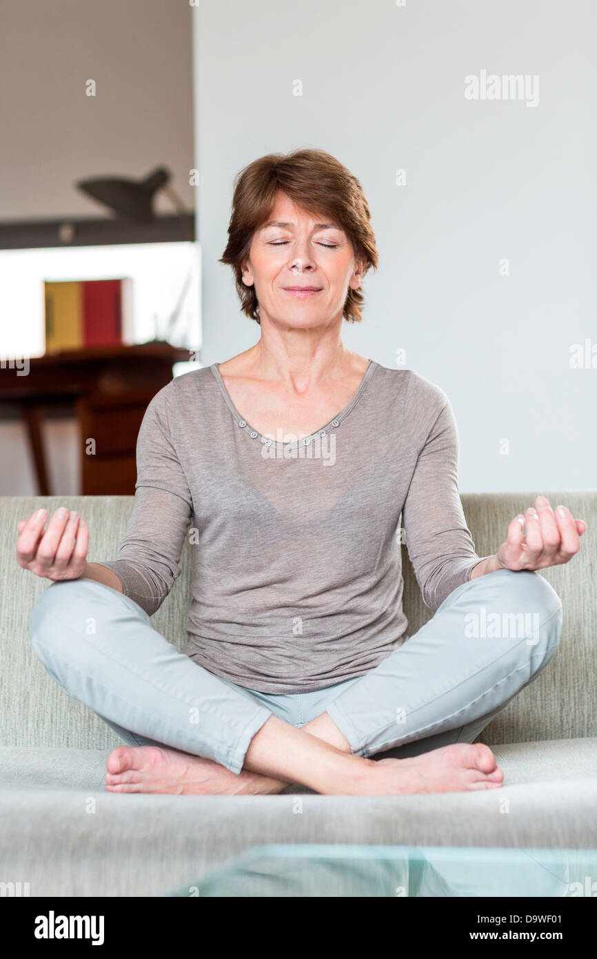 Senior woman sitting in the lotus position Stock Photo