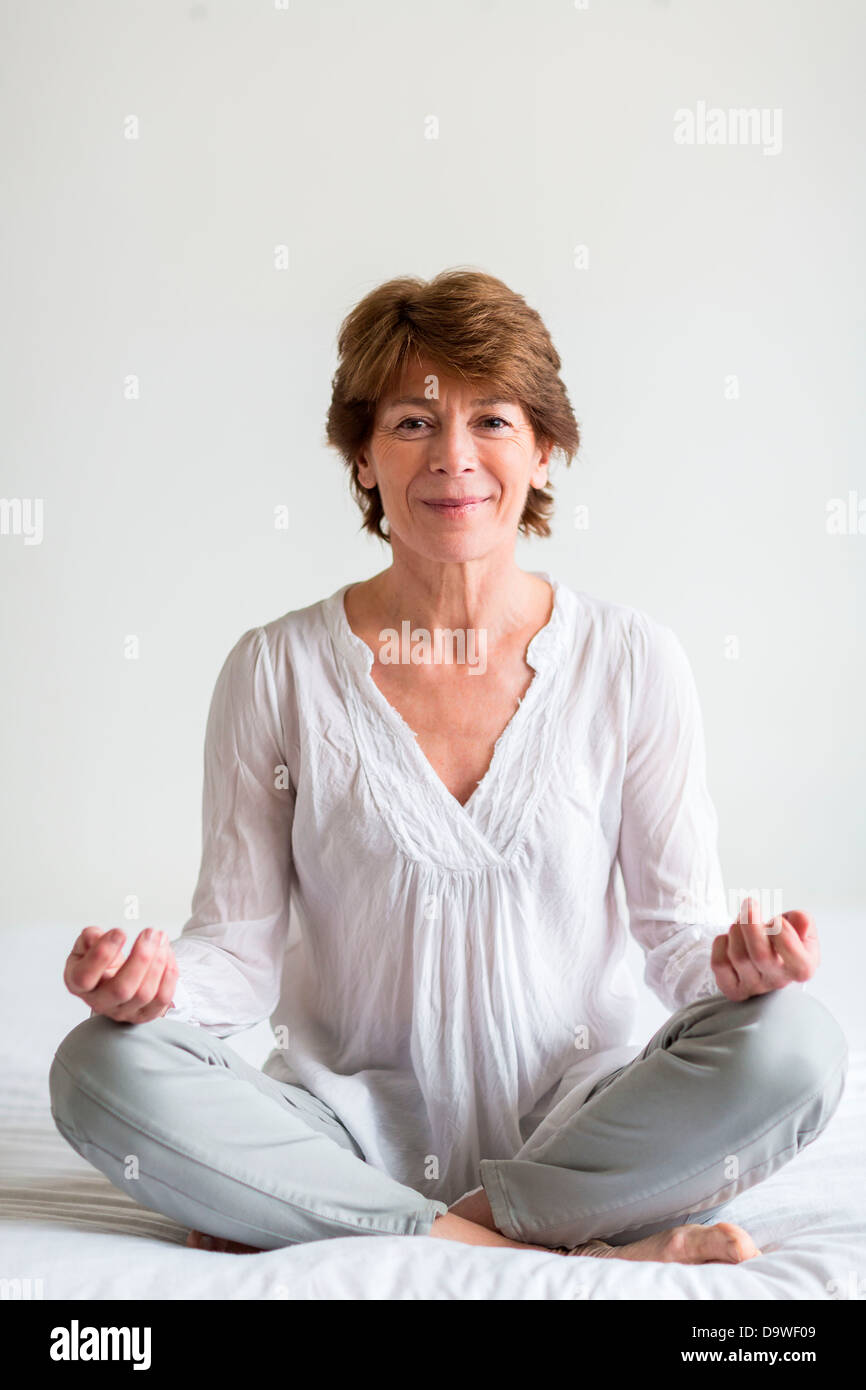 Senior woman sitting in the lotus position Stock Photo