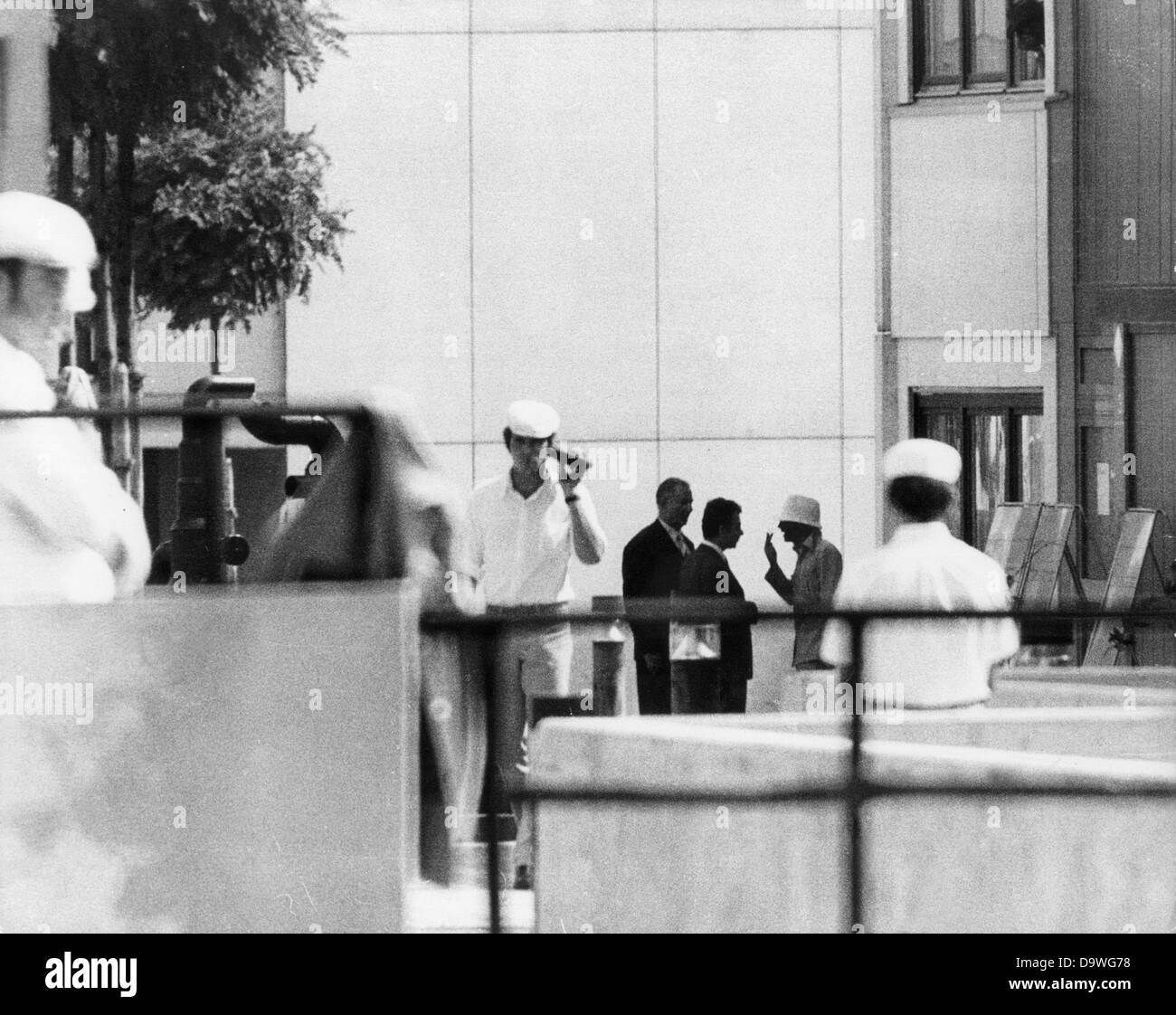 A masked Arab terrorist (2nd of left) talks to members of the negotiating delegation in front of the Israeli team's accomodation in the Olympic Village on the 5th of September in 1972. Arabic terrorists of the group 'Black September' had entered the village in the morning of the 5th of September in 1972, overwhelmed nine athletes and shot two. Their ultimatum: Release of two hundred captured Palestinians and free withdrawal with the remaining hostages. In the evening, the terrorists and the hostages took a helicopter to the military airbase Fuerstenfeldbruck. Hours later, the release operation Stock Photo
