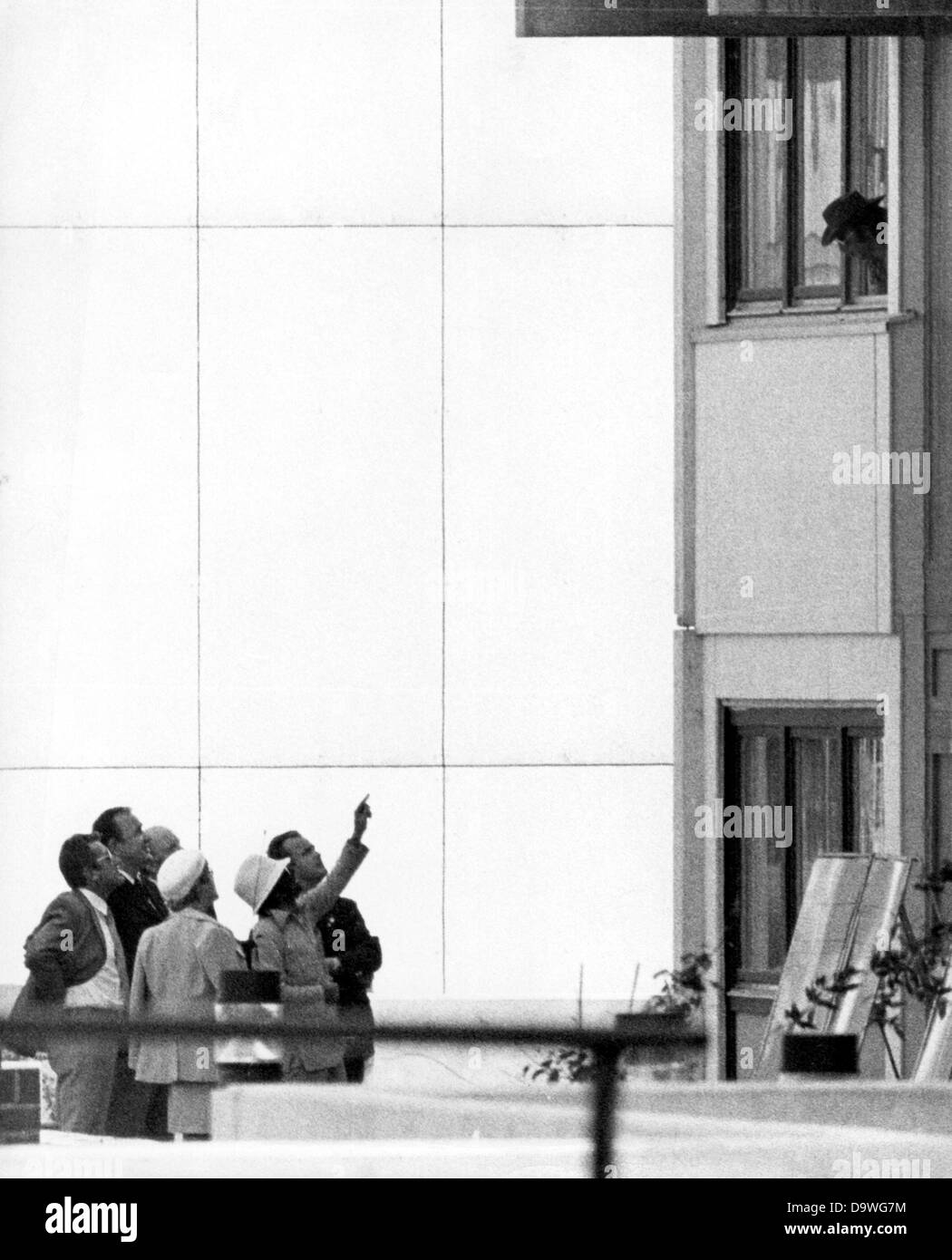 An Arabian terrorist (r, window) is talking from the window of the Israeli team accommodation in the Olympic village of the Munich Summer Games, on 5 September 1972, with the members of a German negotiating delegation, lead by Federal Minister of Interior Hans-Dietrich Genscher (2nd from left). Arabian terrorists of the group 'Black September' had attacked the Israeli accommodation in the Olympic village, killed two Israelis and took nine hostages in the morning of 5th September. Their ultimatum: release of 200 imprisoned Palestinians and free passage with the other hostages. In the evening, t Stock Photo