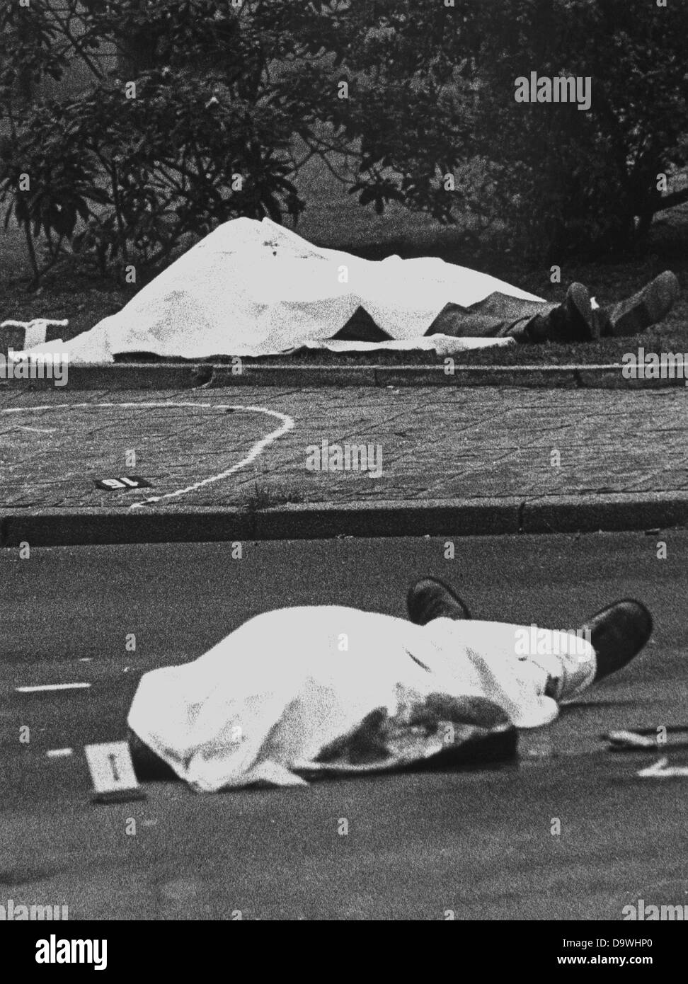 Crime scene with the covered corpses of Siegfried Buback (back) and his driver Wolfgang Göbel, as well as the official car, in which both were shot. The highest prosecutor of the Federal Republic of Germany was killed by the shots of a machine gun, fired from a motorcycle, on the 7th of April in 1977. His driver Wolfgang Göbel died as well, the severely injured judicial officer Georg Wurster died of his injuries on the 13th of April. The 'Command Ulrike Meinhof of the RAF' claimed its responsibility with a letter, which was sent to news agencies. RAF terrorists Knut Folkerts (1980), as well as Stock Photo
