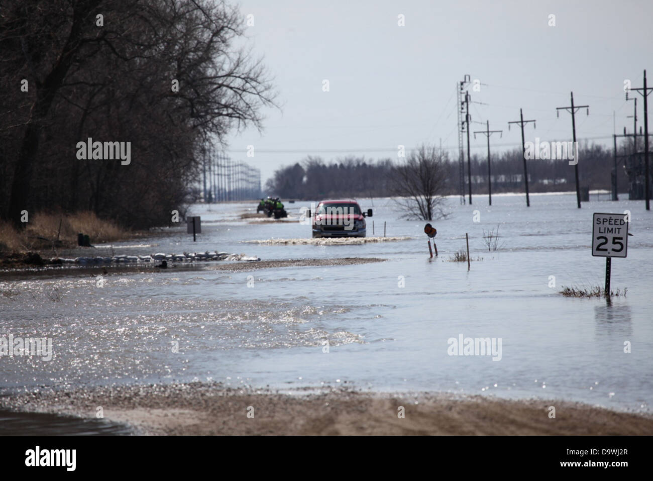 This photograph shows a flooded road near Harwood, North Dakota, along the Red River. The image illustrates the effects of seasonal flooding in the area, highlighting the challenges faced by communities in flood-prone regions. Stock Photo
