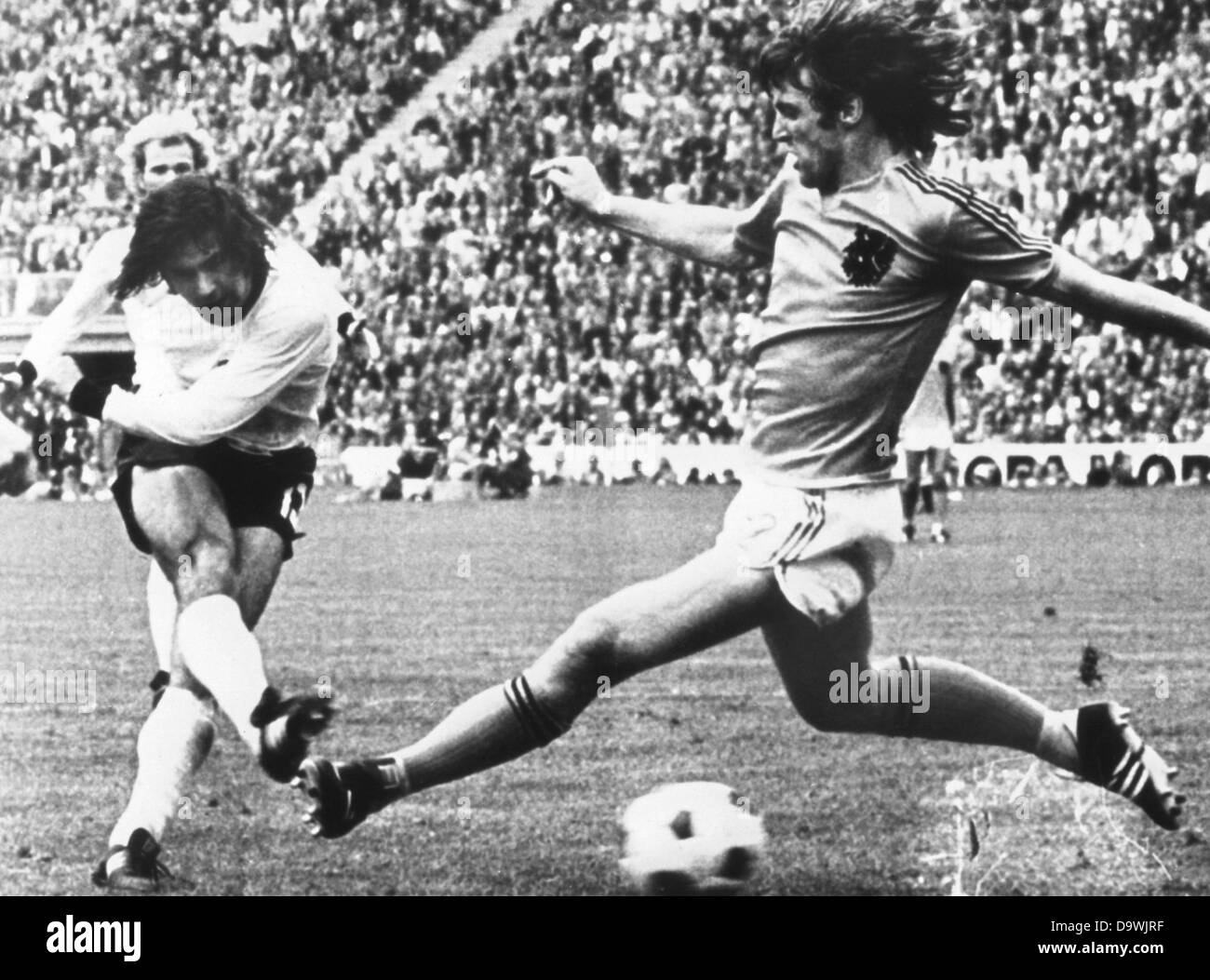 German striker Gerd Müller (l) shoots the 2:1 victory goal in the world championships final on the 7th of July in 1974 in Munich. Right is Dutch defence player Ruud Krol. Stock Photo