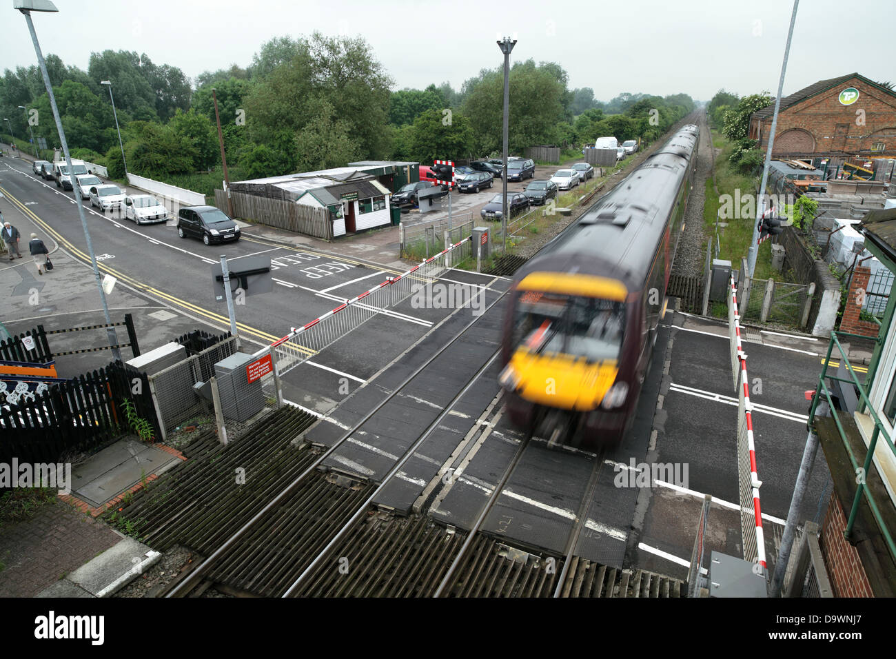 A Birmingham to Leicester train passing over a level crossing at Narborough, Leicestershire. Stock Photo