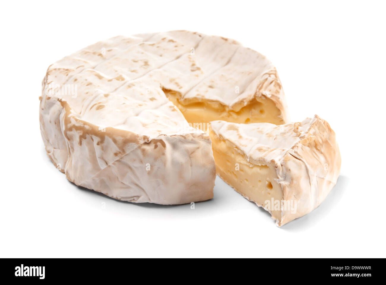 Round Brie cheese with a section cut out over white Stock Photo