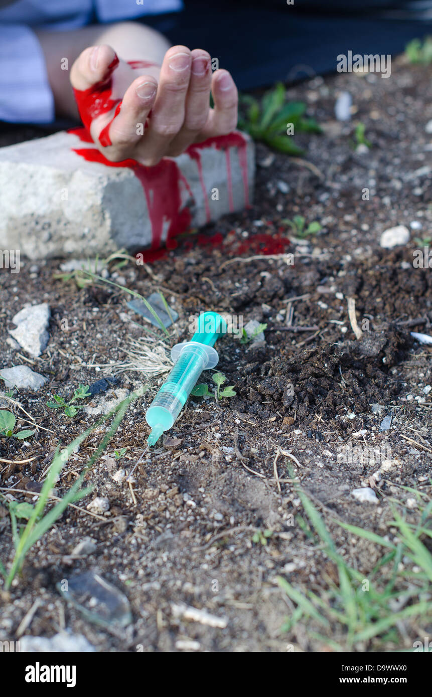 Bloody hand and syringe near it. Crime scene Stock Photo