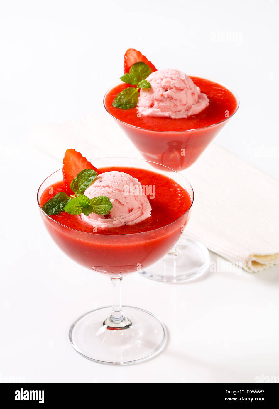 Ice cream with strawberry puree in stemmed glasses Stock Photo