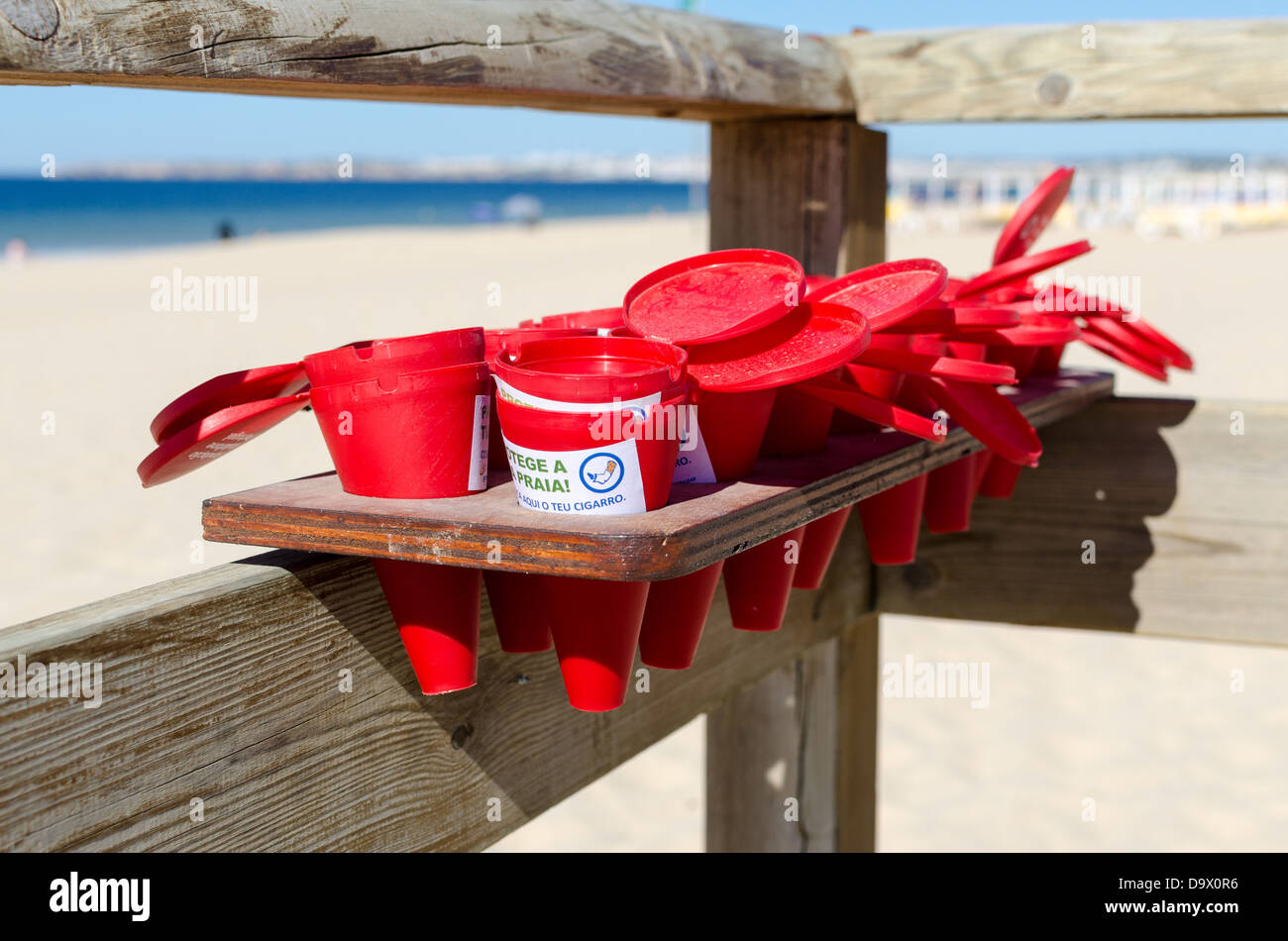 Red containers for cigarette ends provided to beach users in Alvor, Portugal Stock Photo