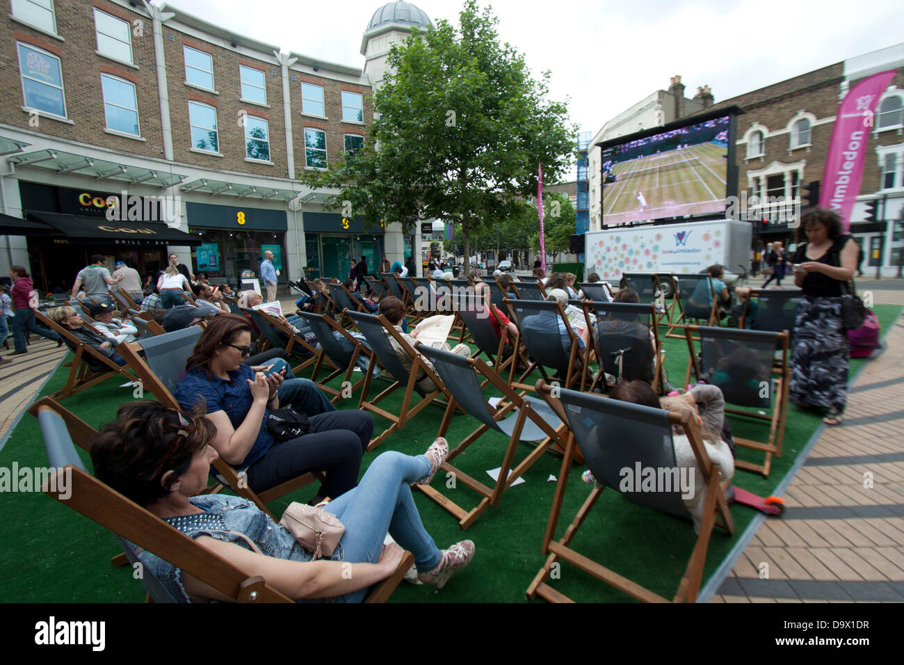 Wimbledon, London, UK. 27th June 2013. Shoppers and members of the public enjoy watching live matches broadcast on  a giant electronic screen in  Wimbledon town centre Credit:  amer ghazzal/Alamy Live News Stock Photo