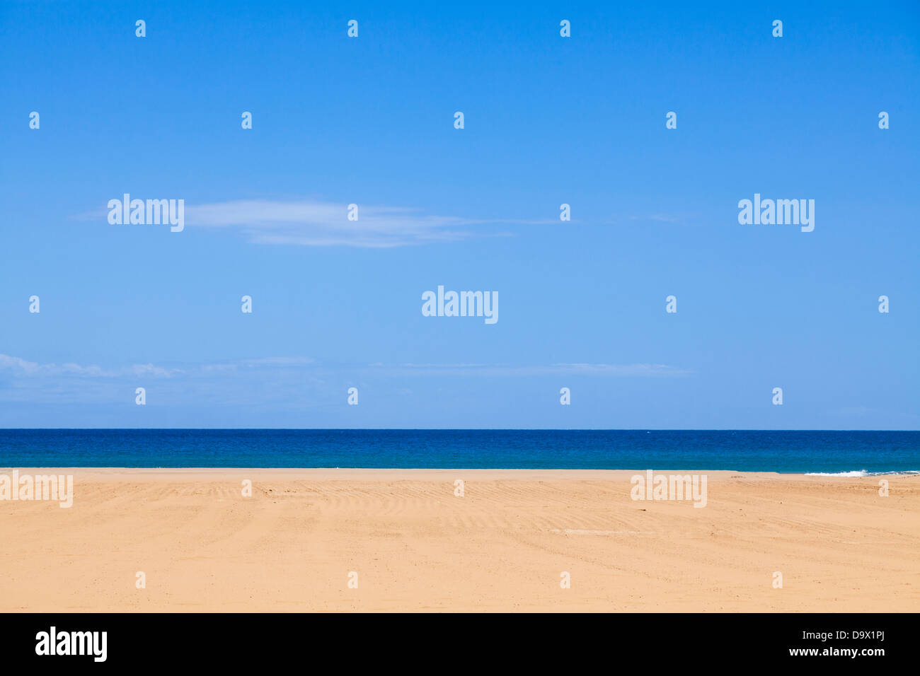 Horizontal lines of sandy beach with blue sea and sky. Stock Photo