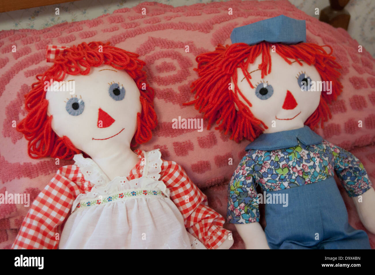Raggedty Ann dolls and Andy dolls lying on a bed. Stock Photo