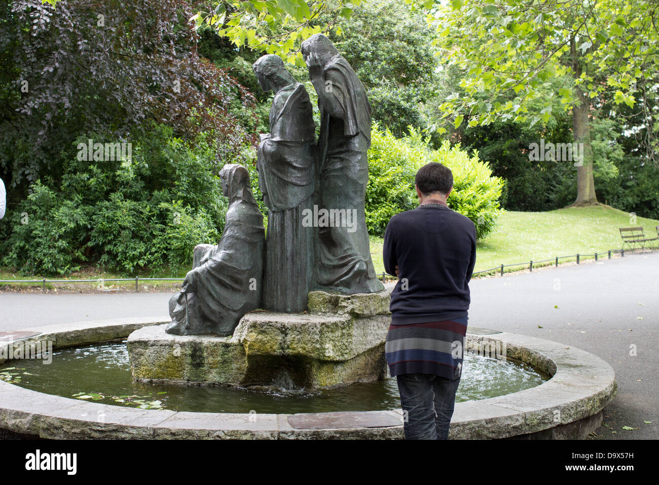 A man stands beside a fountain with three statues in St. Stephen's