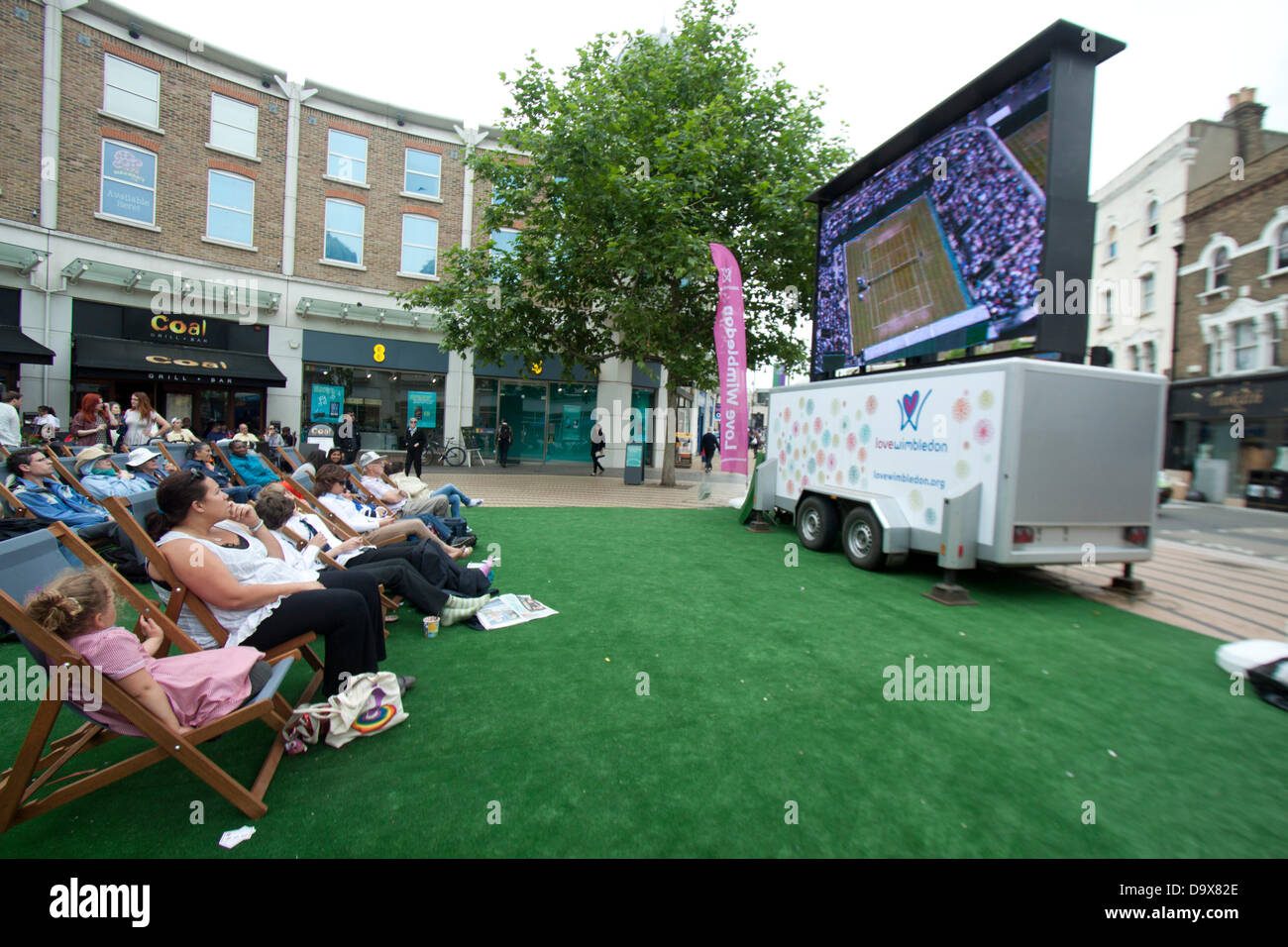 Wimbledon, London, UK. 27th June 2013.  Shoppers and members of the public enjoy watching live matches broadcast on  a giant electronic screen in  Wimbledon town centre. Credit:  amer ghazzal/Alamy Live News Stock Photo