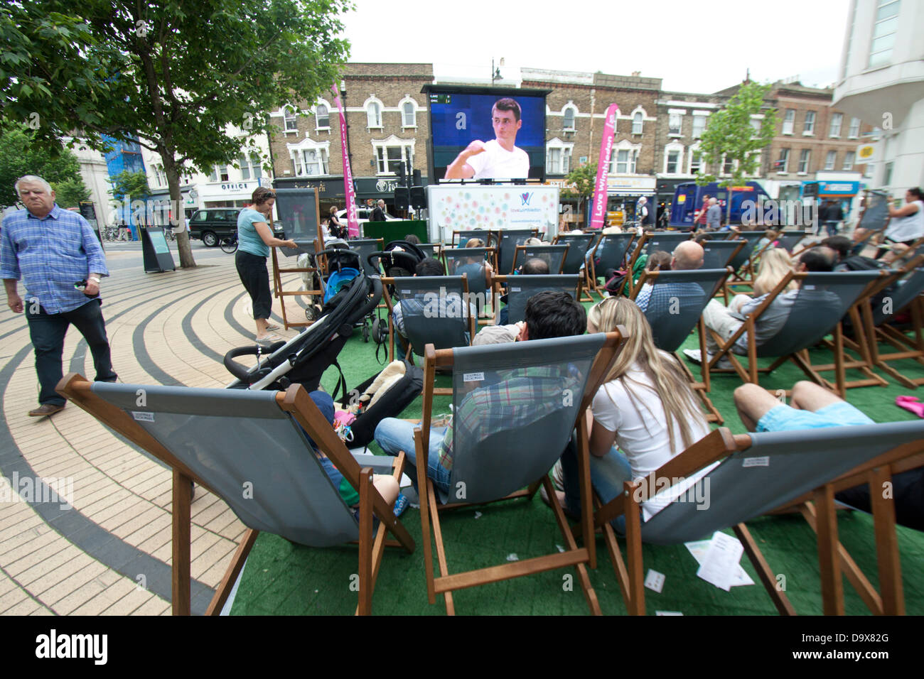 Wimbledon, London, UK. 27th June 2013.  Shoppers and members of the public enjoy watching live matches broadcast on  a giant electronic screen in  Wimbledon town centre. Credit:  amer ghazzal/Alamy Live News Stock Photo