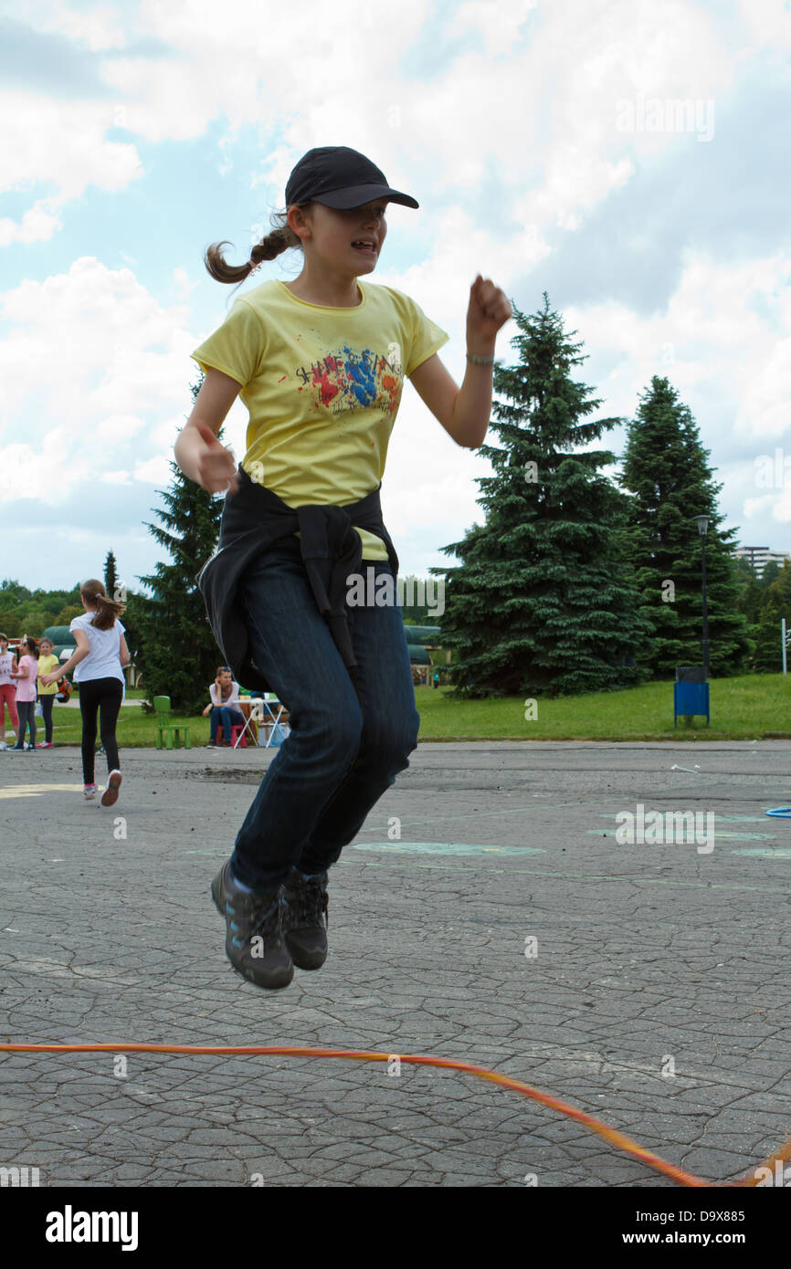 Girl jumping over a skipping rope Stock Photo - Alamy