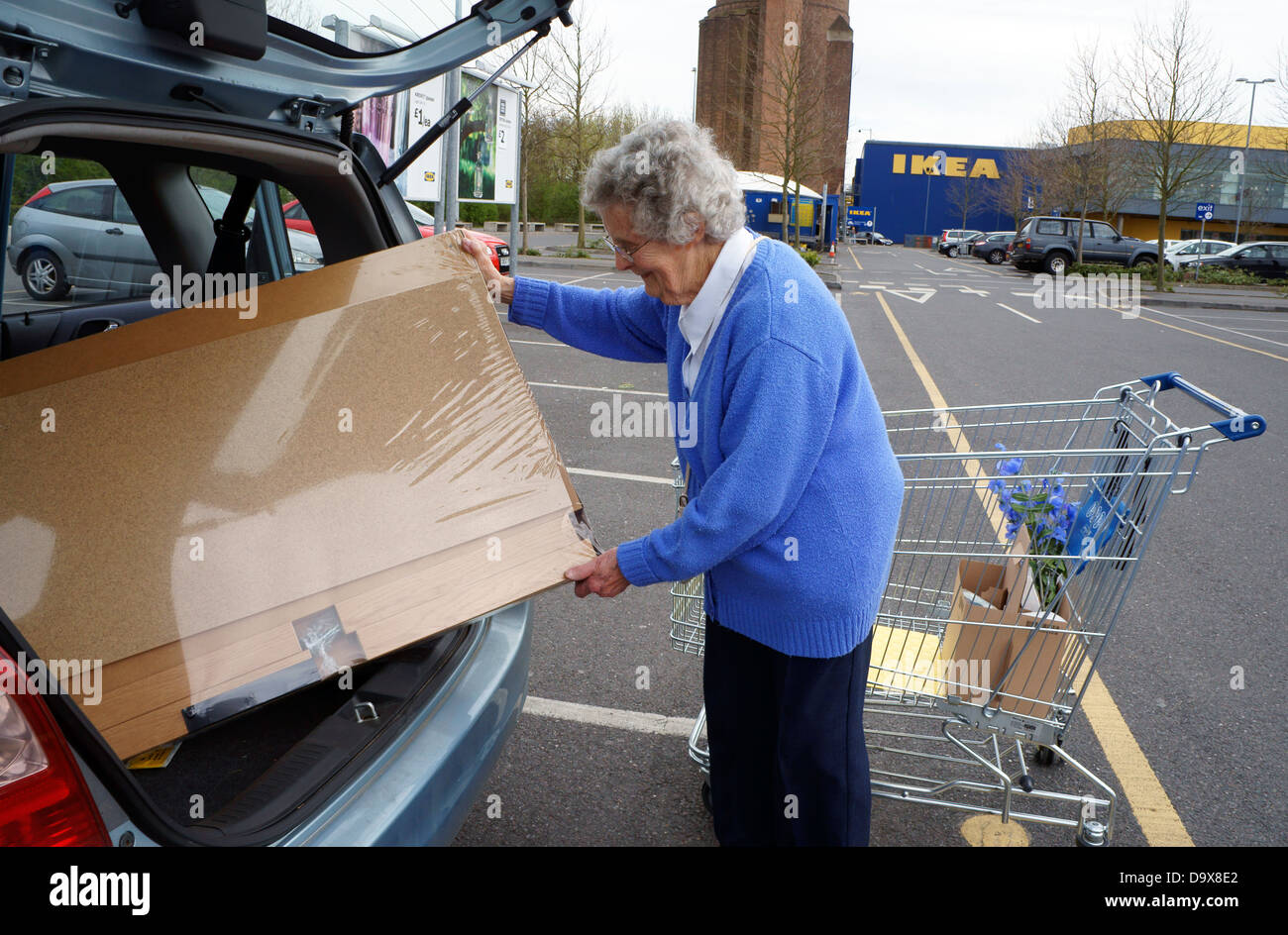Senior woman loading Ikea flatpack furniture into her car Stock Photo 