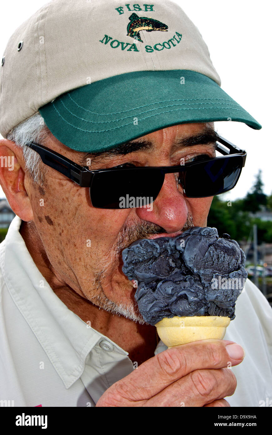 Man eating baby liquorice ice cream cone Discovery Fishing Pier food concession stand Stock Photo