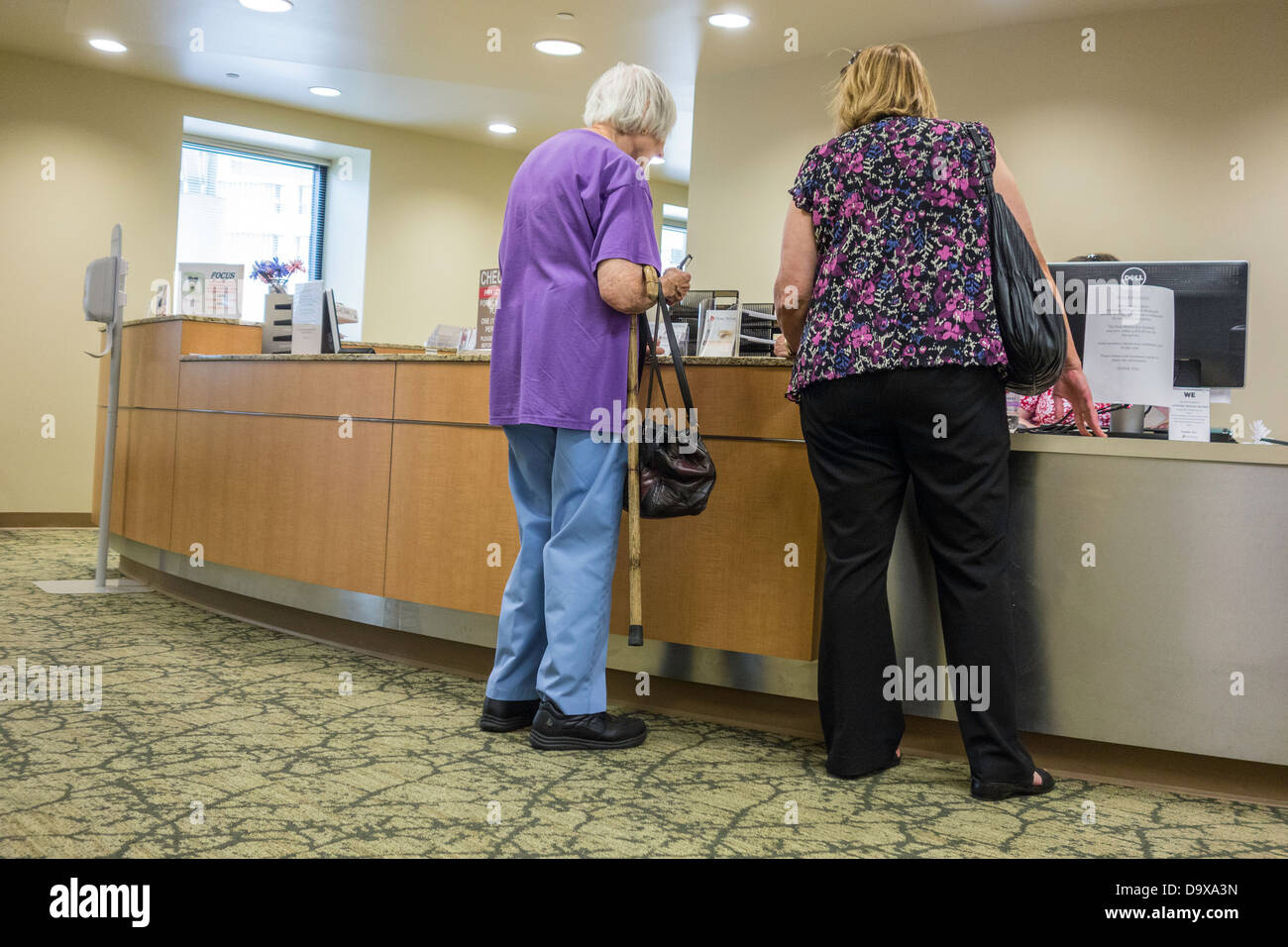 A daughter registers her elderly mother to be seen at the Dean McGee Eye Institute in Oklahoma City, Oklahoma. USA Stock Photo