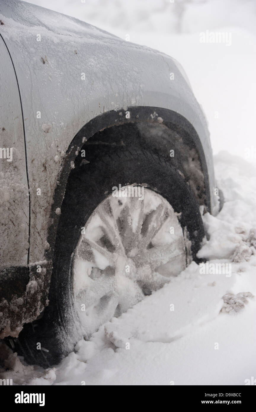 Close up of car wheels stuck in snow drift. Stock Photo