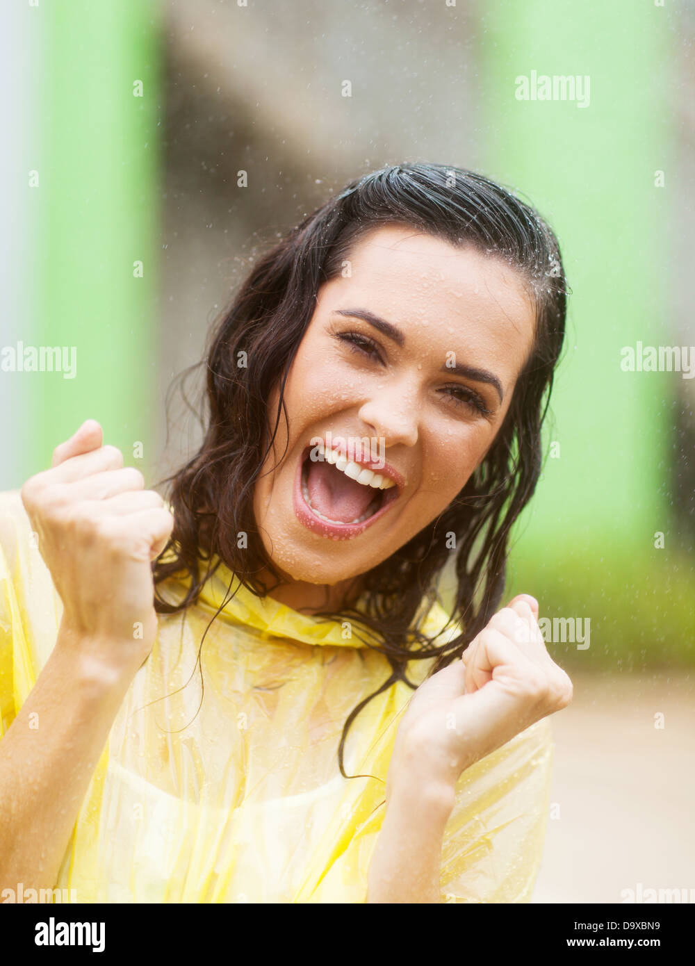 cheerful young woman waving fist in the rain Stock Photo