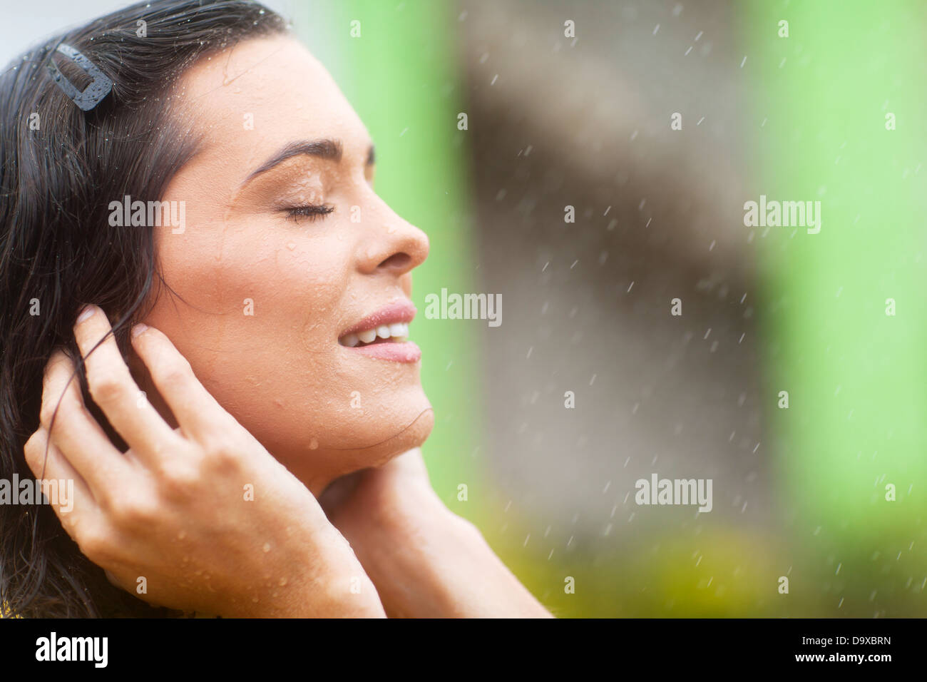 happy young woman enjoying rain falling on her face Stock Photo