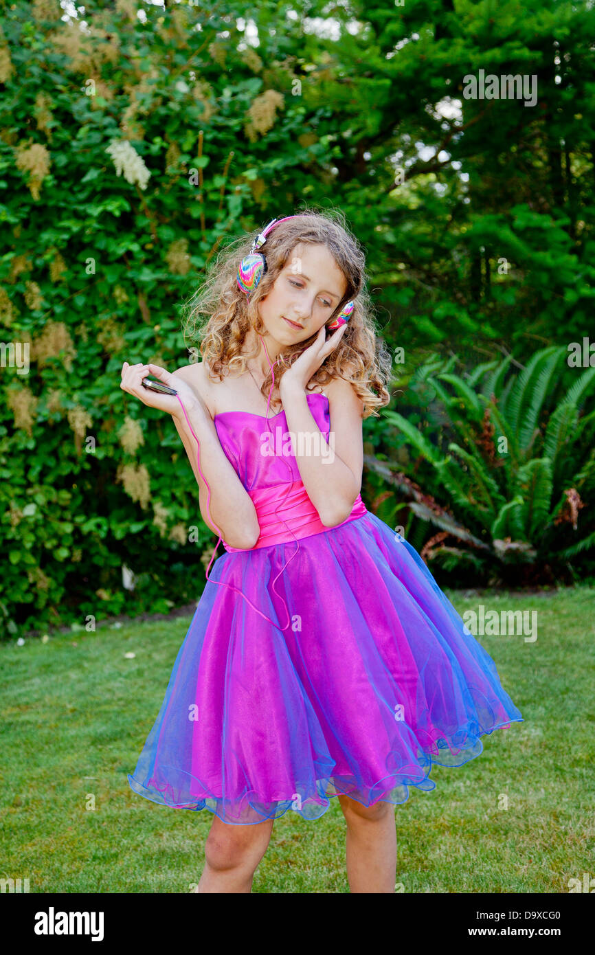 Teen girl in party dress listening to music outdoors Stock Photo Alamy