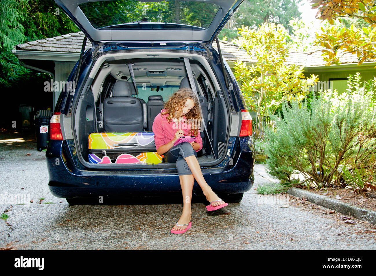 Teen girl with luggage in car Stock Photo