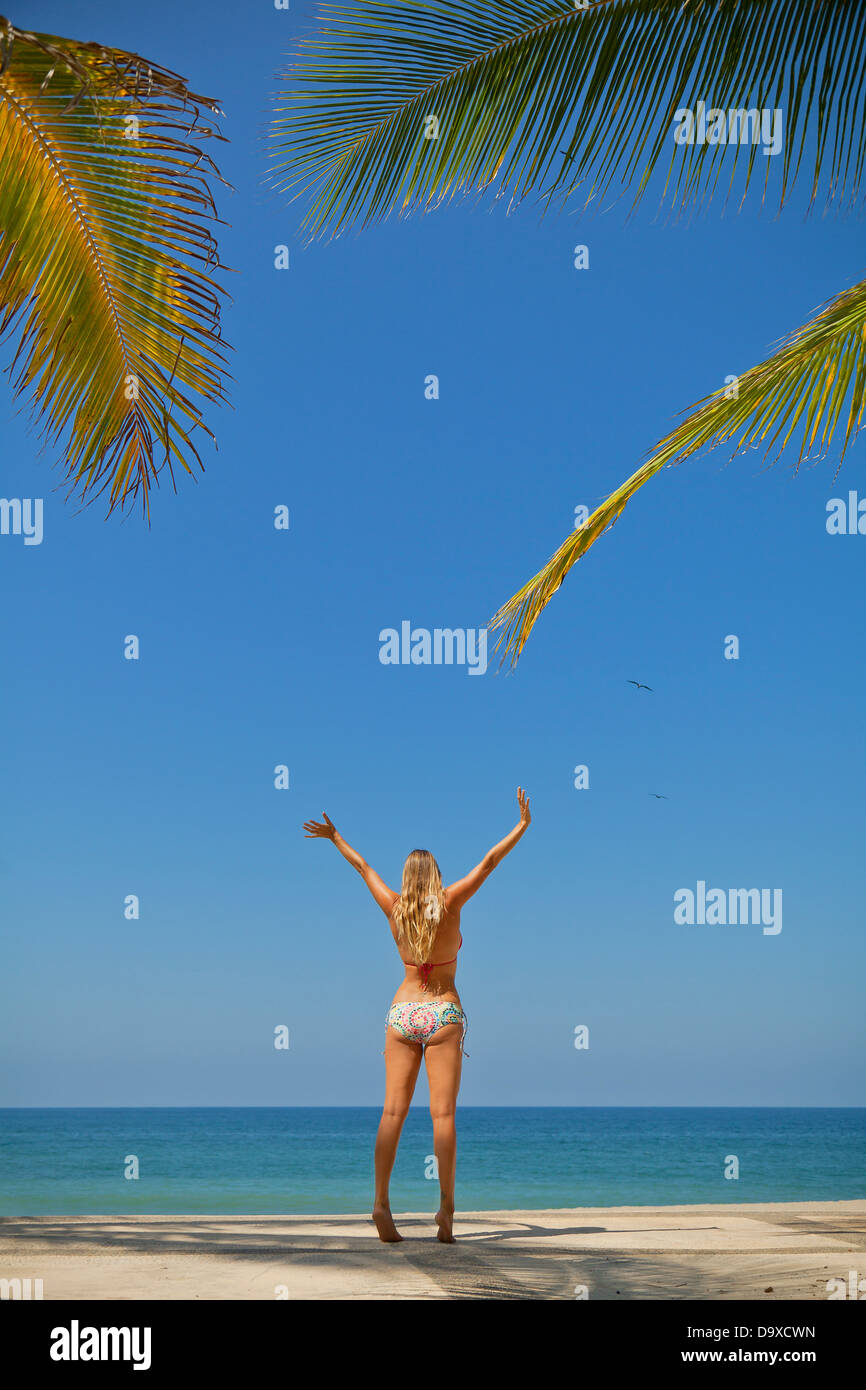 Woman in bikini jumping on beach Stock Photo
