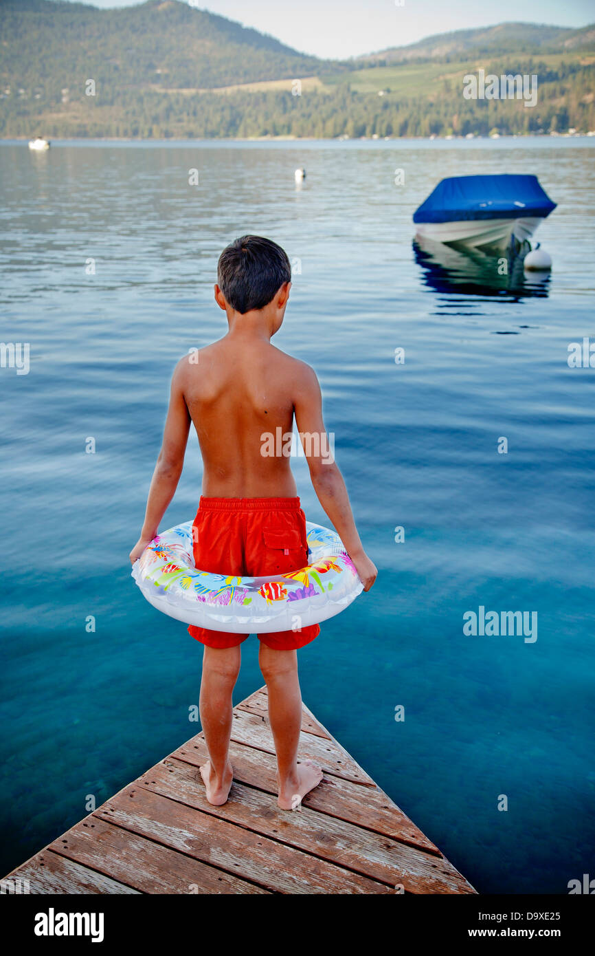 Young boy wearing float ring on dock Stock Photo