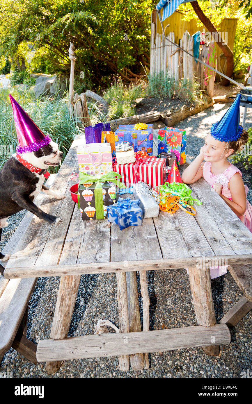 Young girl and dog at outdoor birthday paty Stock Photo