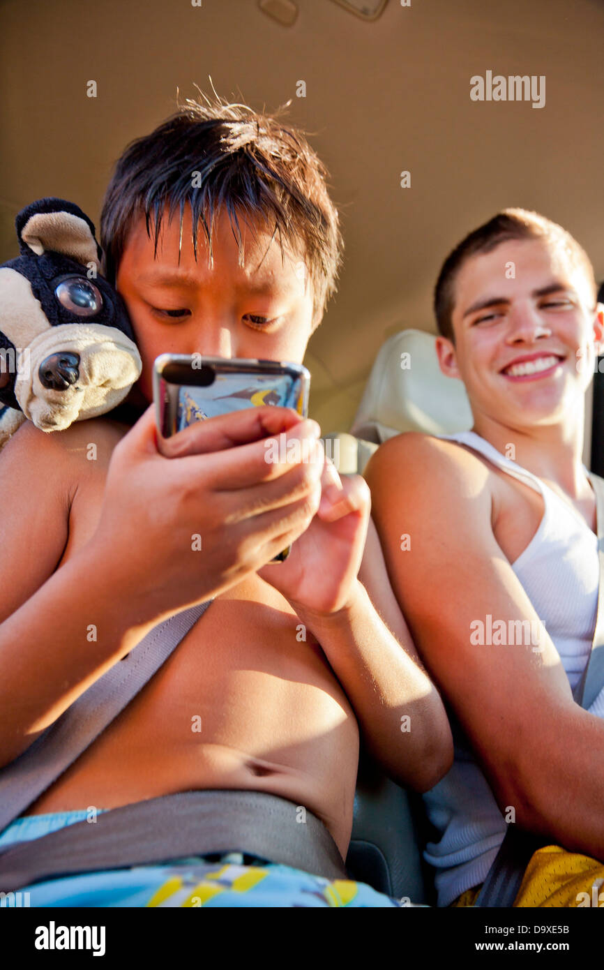 Boys in backseat of car with phone Stock Photo