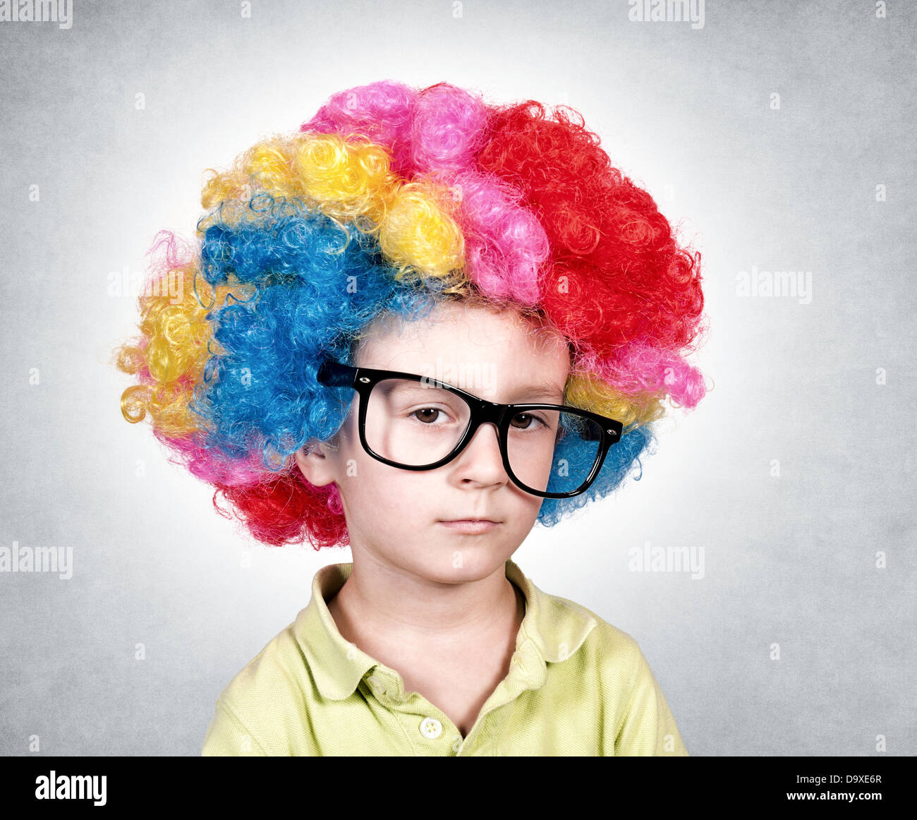 Bored boy with the clown wig on head Stock Photo Alamy