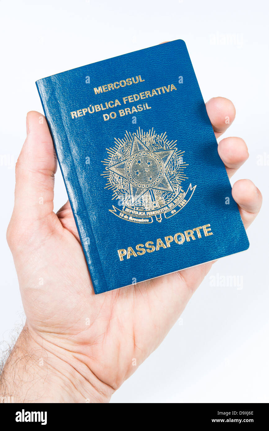 Male hand holding Brazilian passport. Isolated on white background