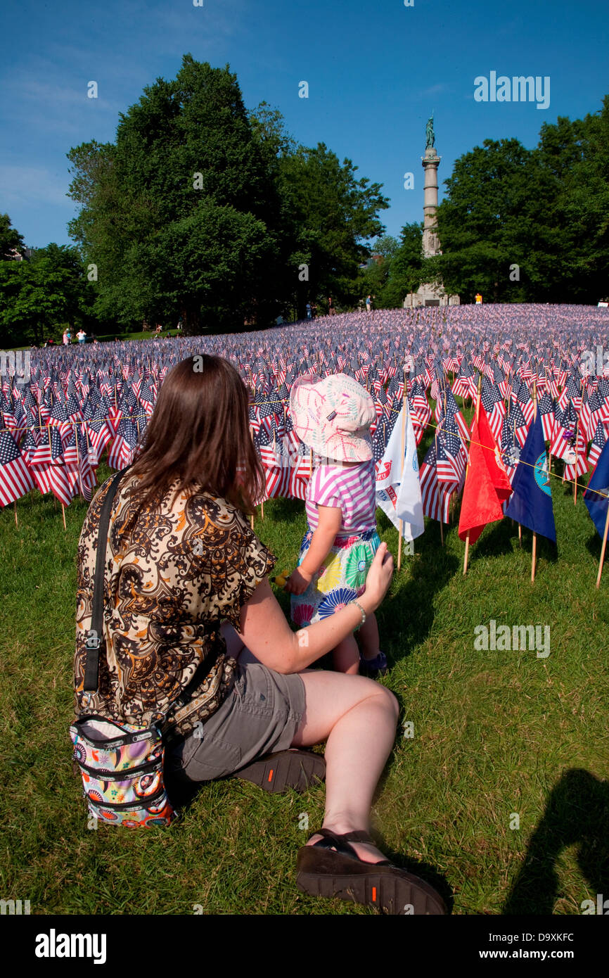 Mother shows baby 20,000 American Flags are displayed for every resident Massachusetts who died in war over past 100 years Stock Photo