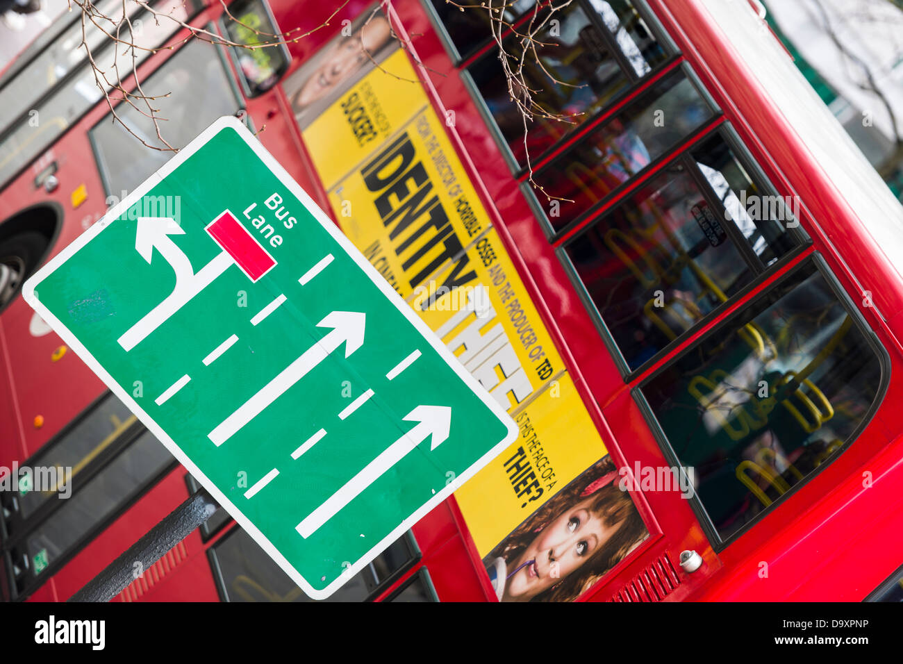 A red London Bus passes a Bus Lane sign in the city centre Stock Photo