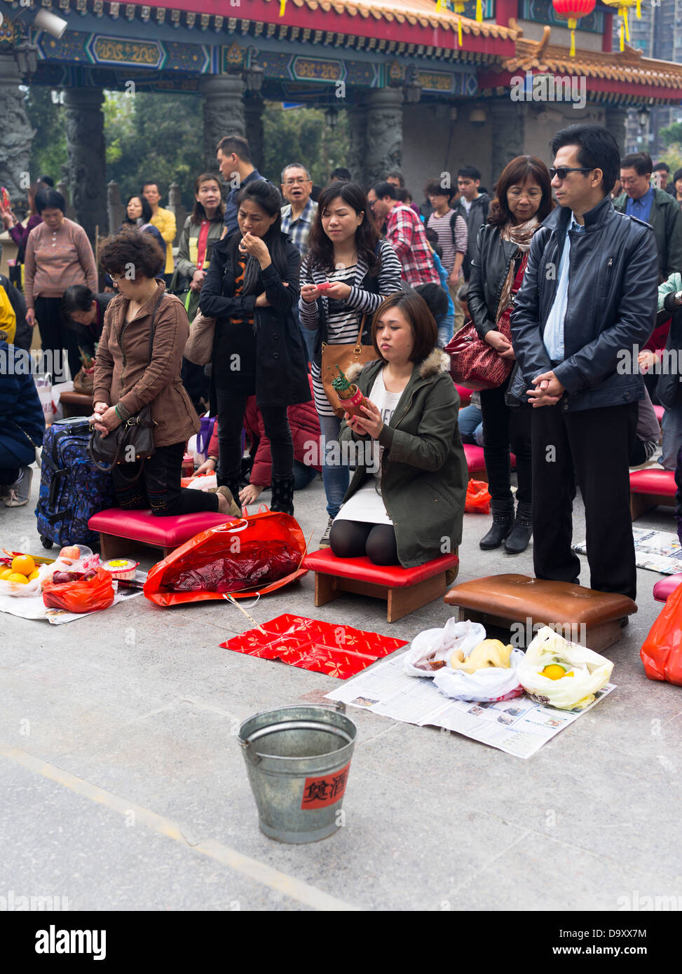 dh Fortune sticks taoist WONG TAI SIN HONG KONG Chinese Girl worshipper with bamboo holder selecting kau cim people worship temple china Stock Photo