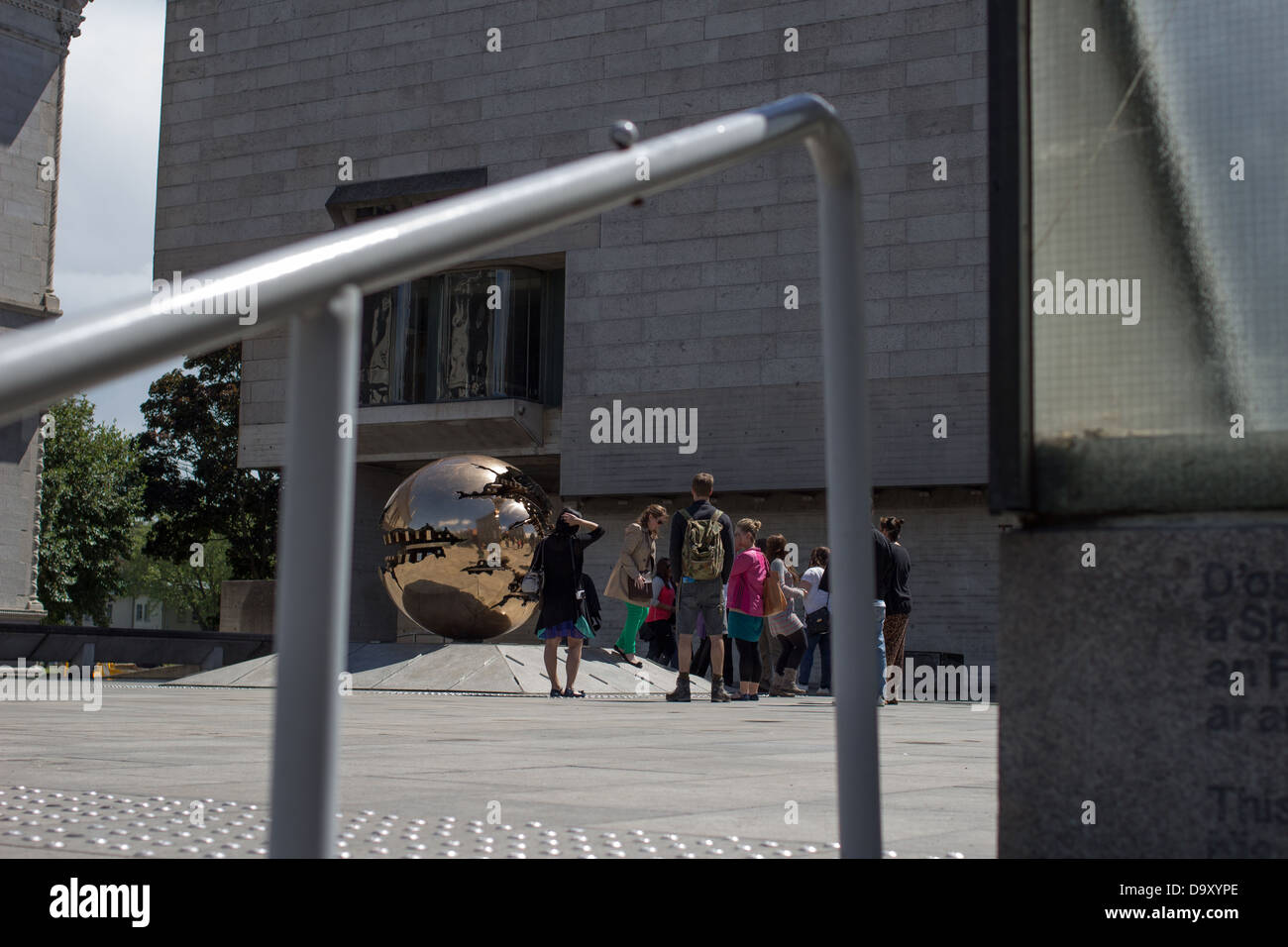 Visitors/students to the Trinity College in Dublin in front of a sculpture. Stock Photo