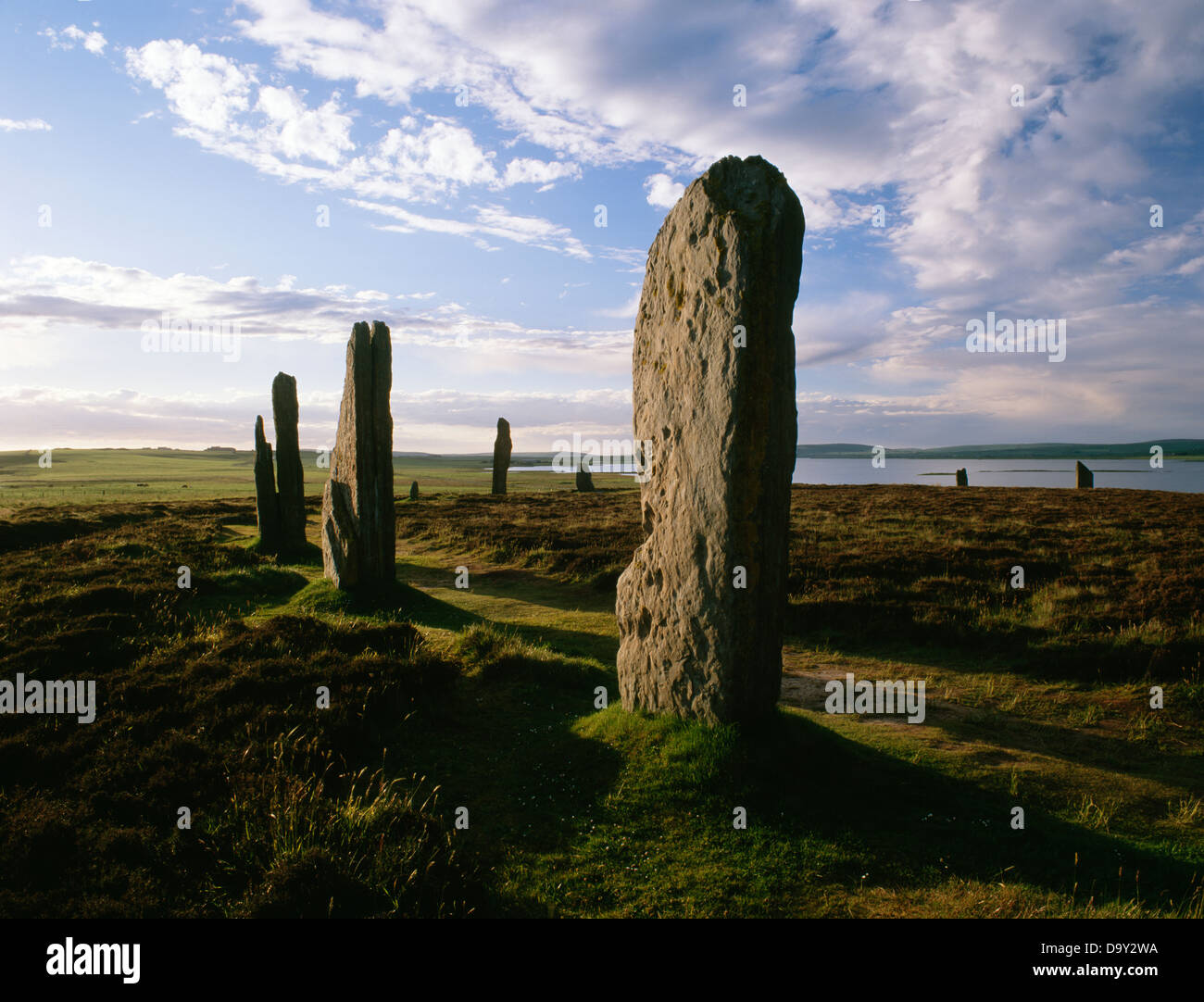 Evening at the Ring of Brodgar henge and stone circle; looking through the western arc of stones to the Loch of Harray Stock Photo