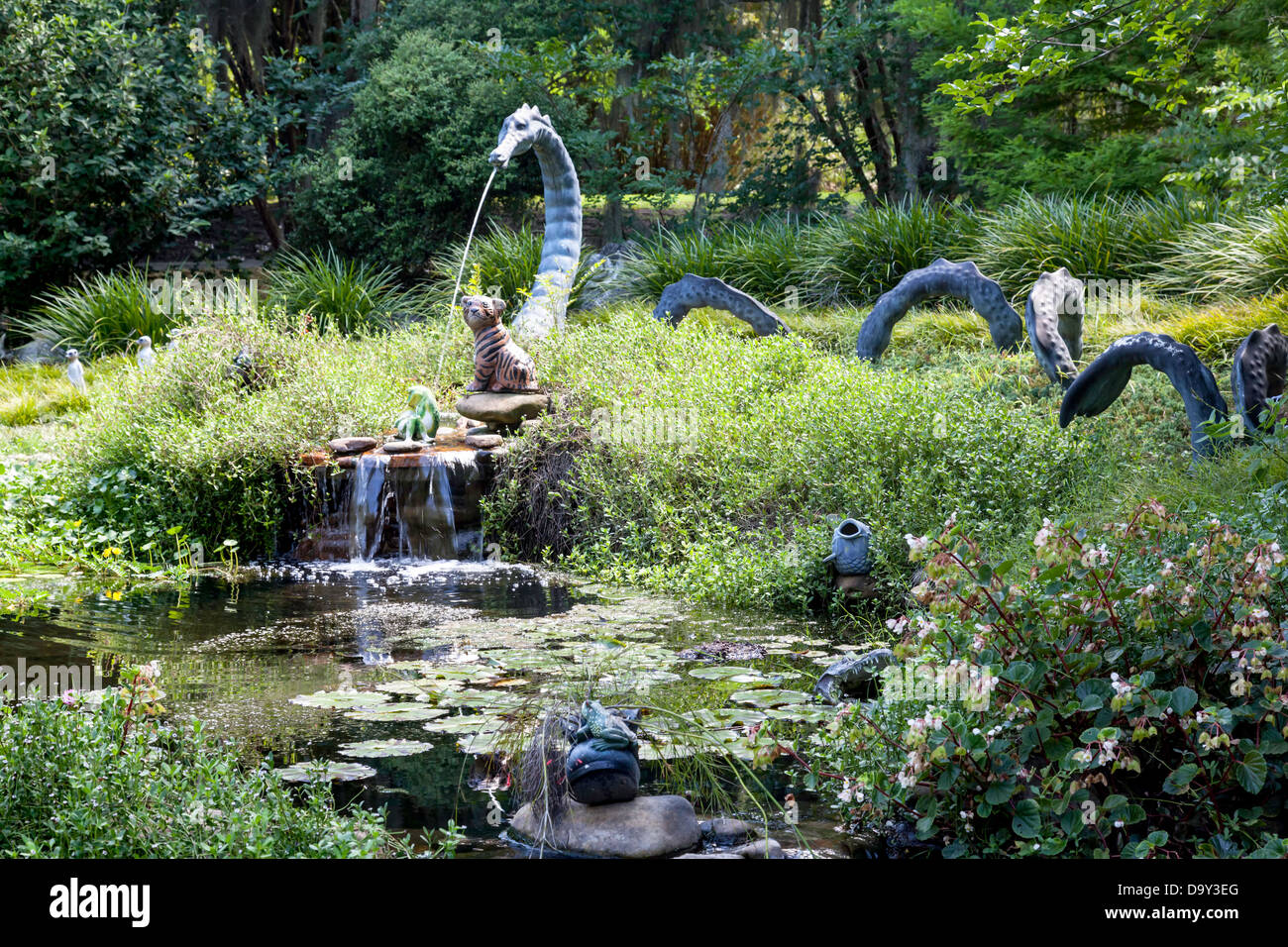 Whimsical dragons and other garden sculptures on display around a pond and waterfall in childrens' garden of Kanapaha Gardens. Stock Photo
