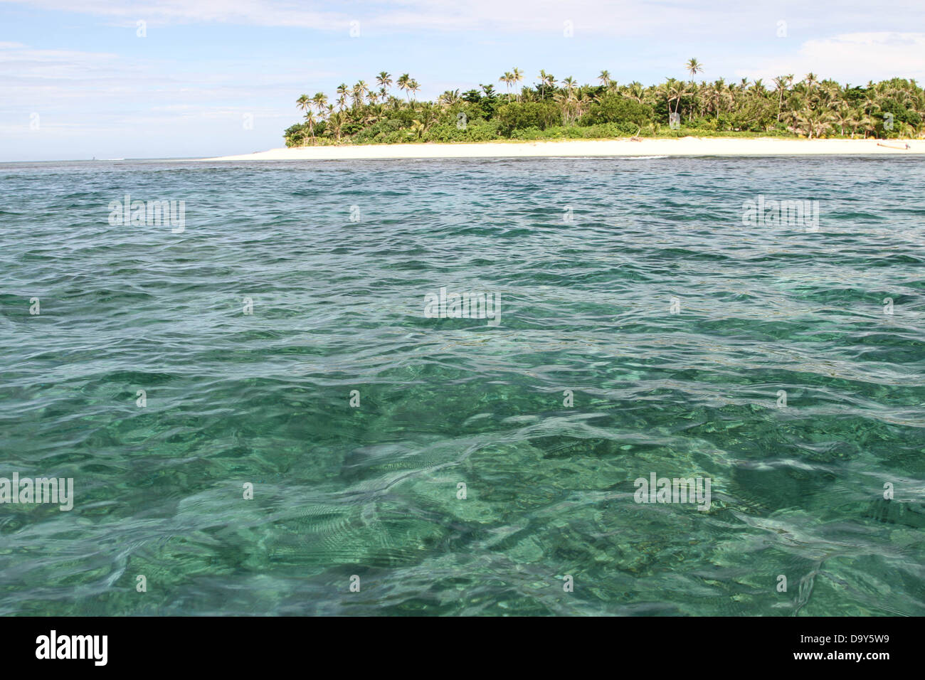 tropical island surrounded by clear water Stock Photo