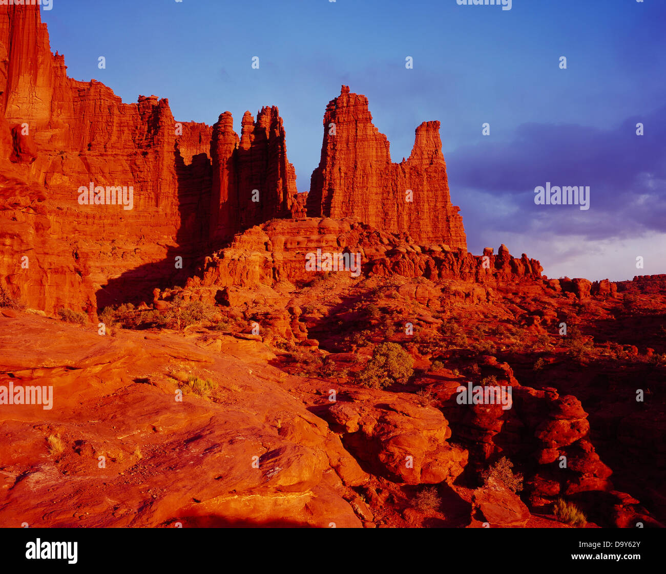 Sunset illuminating Fisher Towers erosional spires capped with harder Moenkopi Formation sandstone with softer Cutler Formation Stock Photo