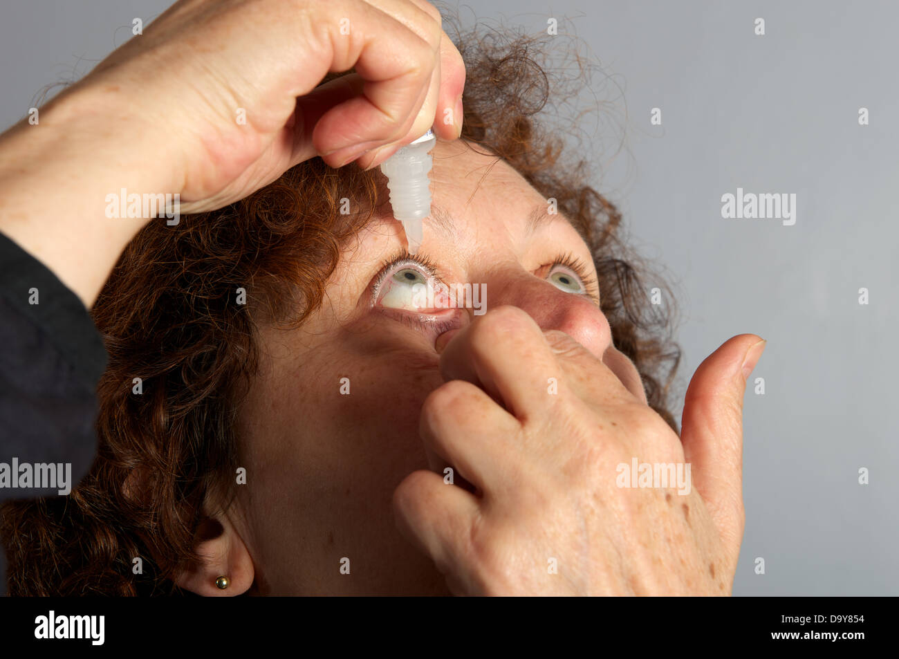 Hay fever sufferer using eye drops Stock Photo