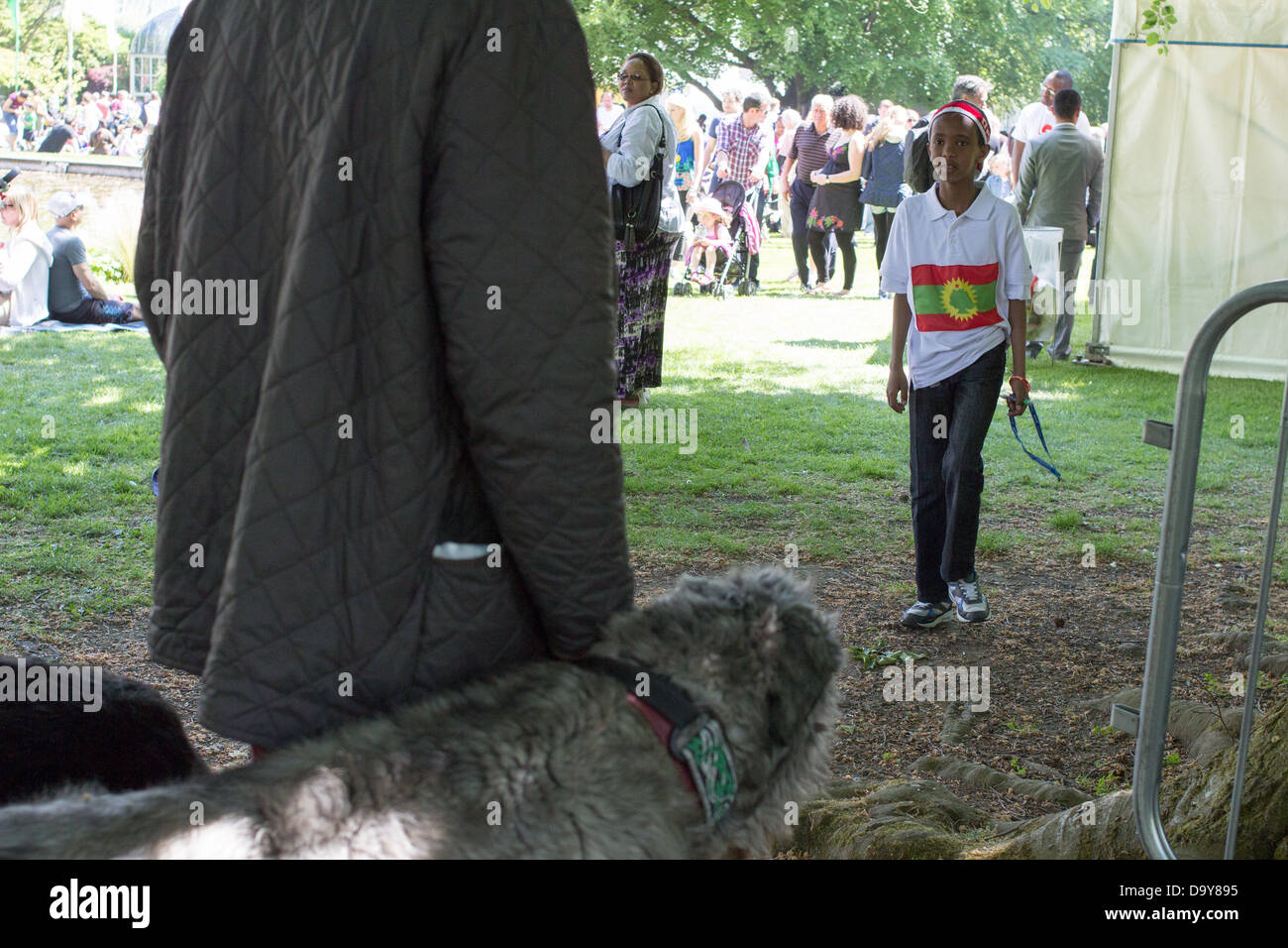 A boy looks at the man holding a large dog on a dog-lead. Stock Photo