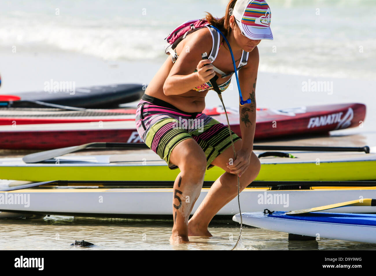 Female Paddle boarder checks out her board ready for the race at Siesta