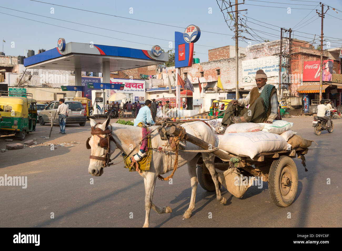India, Uttar Pradesh, Agra, horse and cart passing in front of fuel garage Stock Photo
