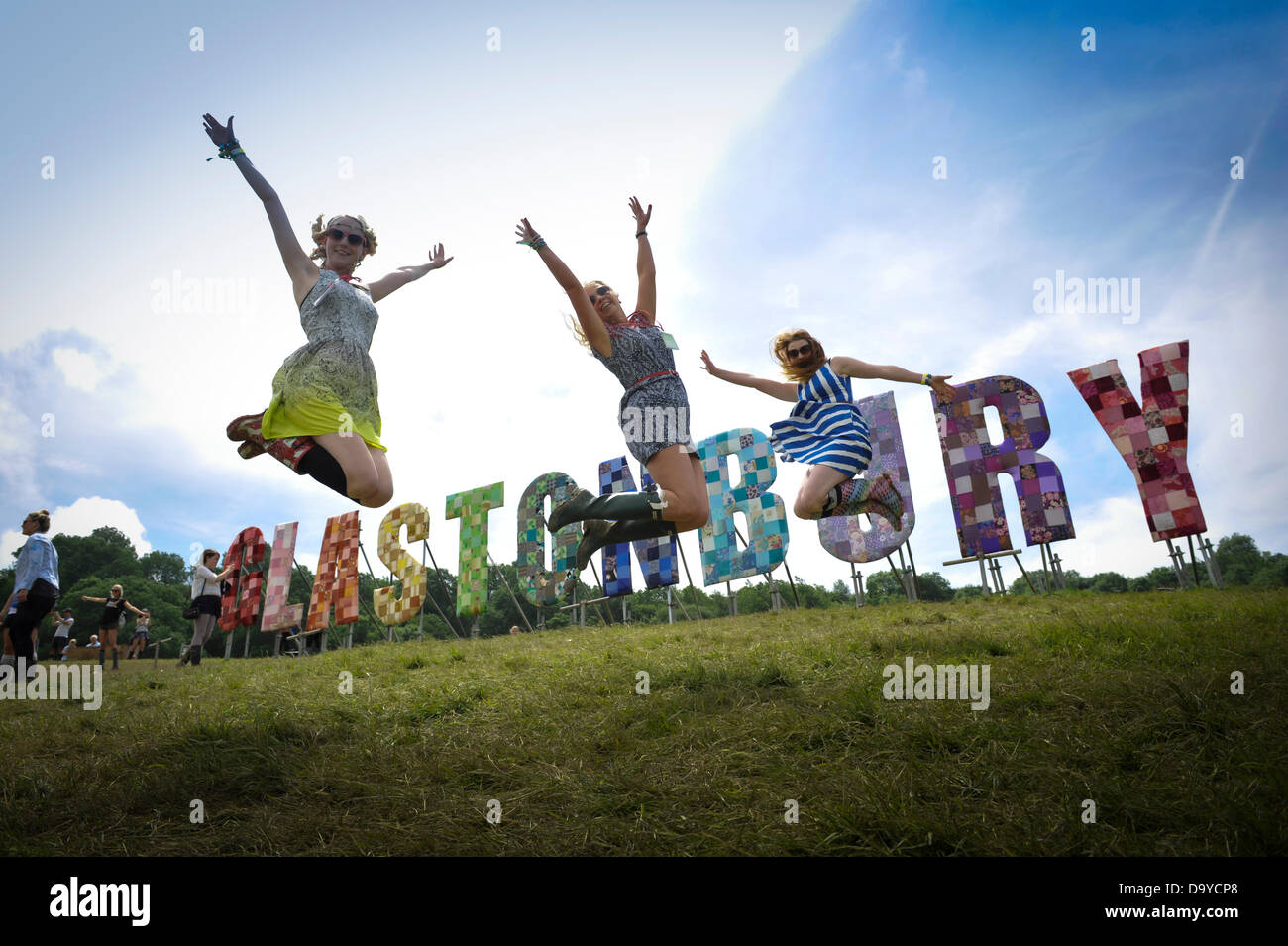 Glastonbury, UK. 28th June 2013. GLASTONBURY MUSIC FESTIVAL Festival goers jumping with excitement in from of large letters that spell out Glastonbury. Its estimated 200,000 people will attend the four day Glastonbury Festival which takes place at Worthy Farm, Pilton Somerset.  June 28. 2013. GLASTONBURY MUSIC FESTIVAL PILTON, SOMERSET, ENGLAND, UK Credit:  Alistair Heap/Alamy Live News Stock Photo